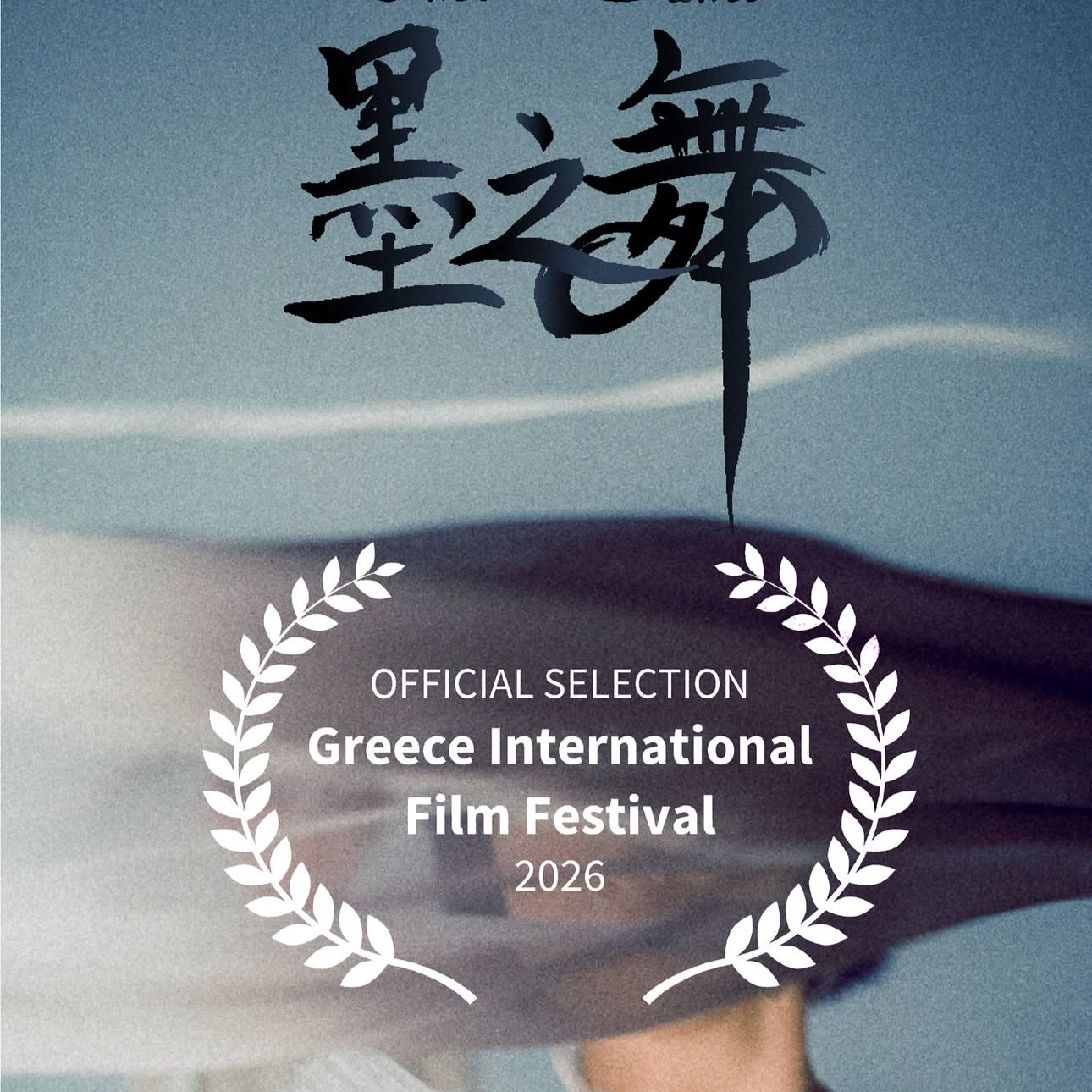 A poster for the 2026 Greece International Film Festival, featuring a stylized, black calligraphic text and a laurel wreath, with a background of a sand dune landscape and a person partially visible.