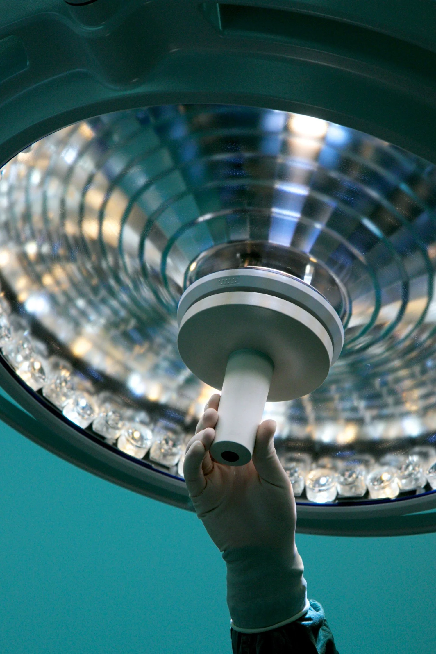 Operating theatre light with surgeon's hand adjusting it