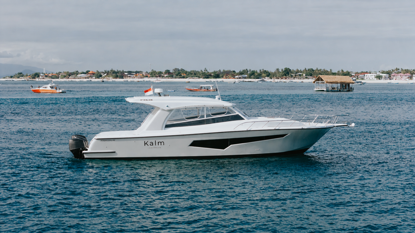 Side profile of the Kalm Charters vessel cruising on open water.