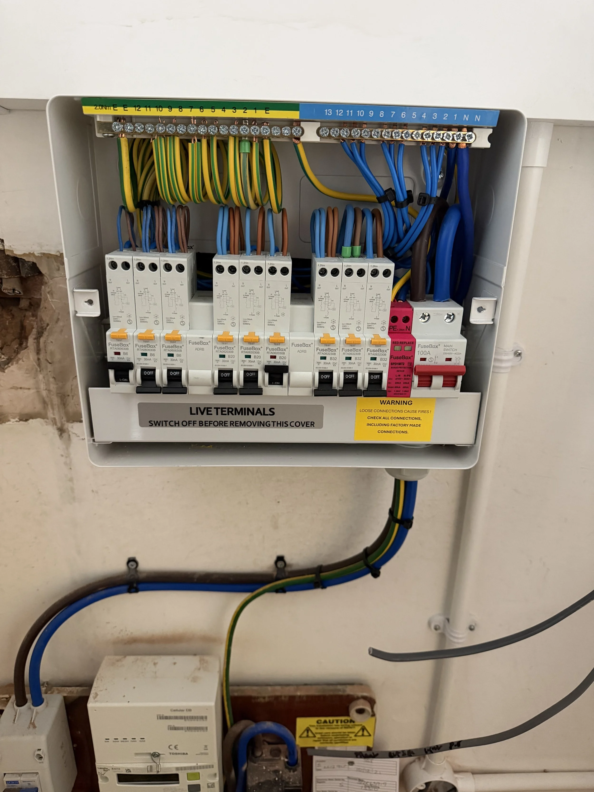 An electrical breaker panel with multiple wires and switches, including labels, warnings, and circuit breakers.