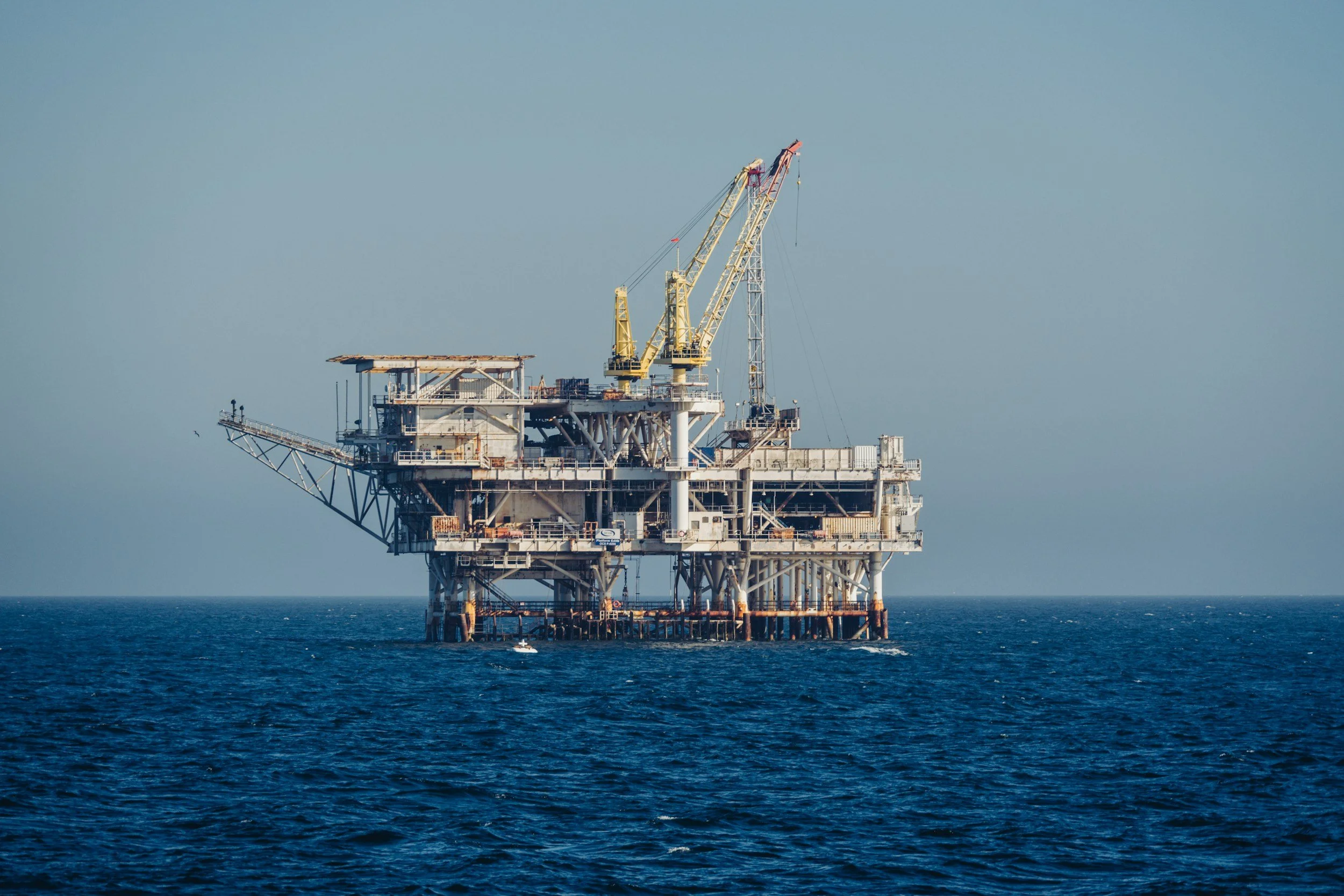 Offshore oil rig in the ocean with clear blue sky in the background.