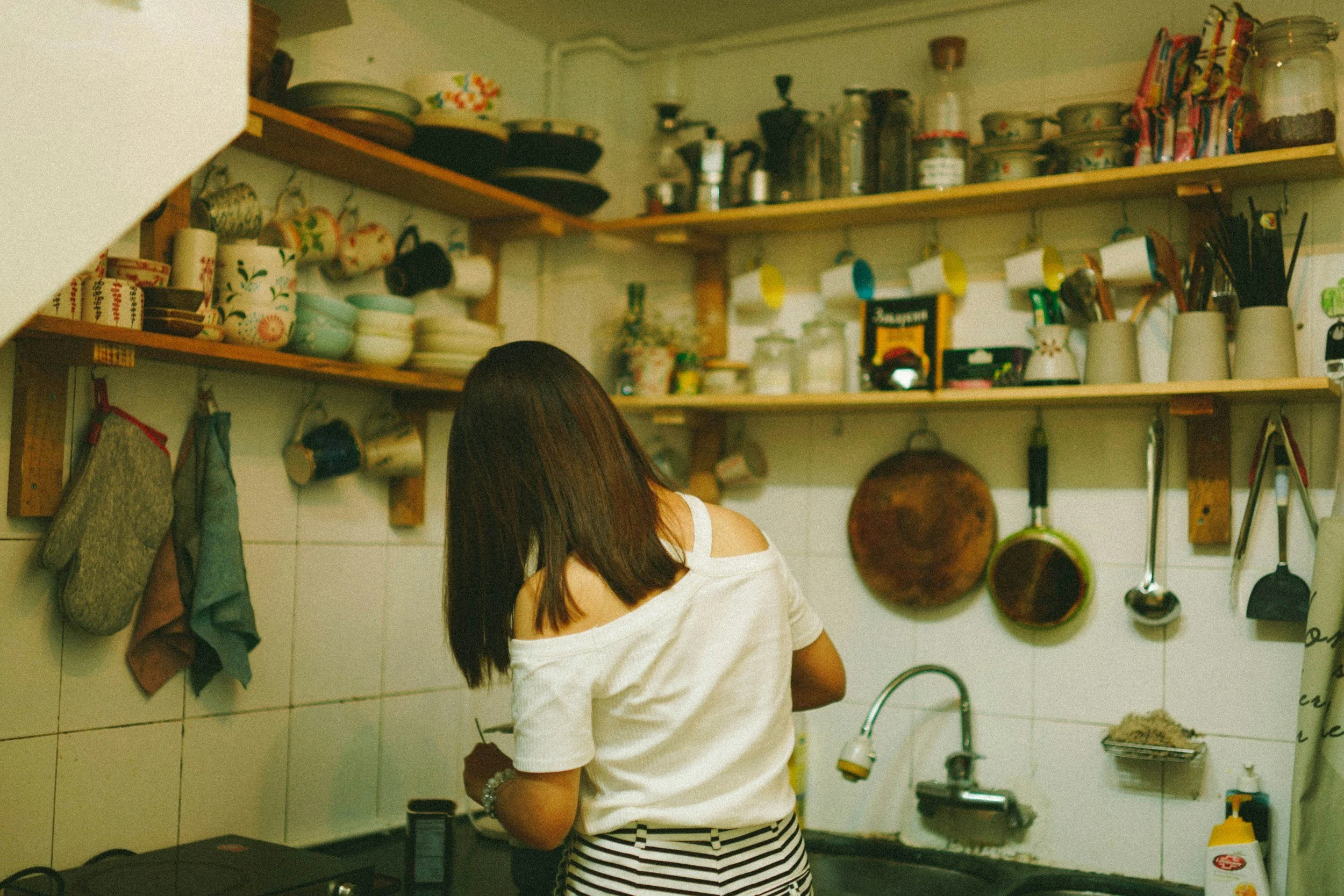 Woman making coffee in her kitchen, distracted by mental chatter about smoking