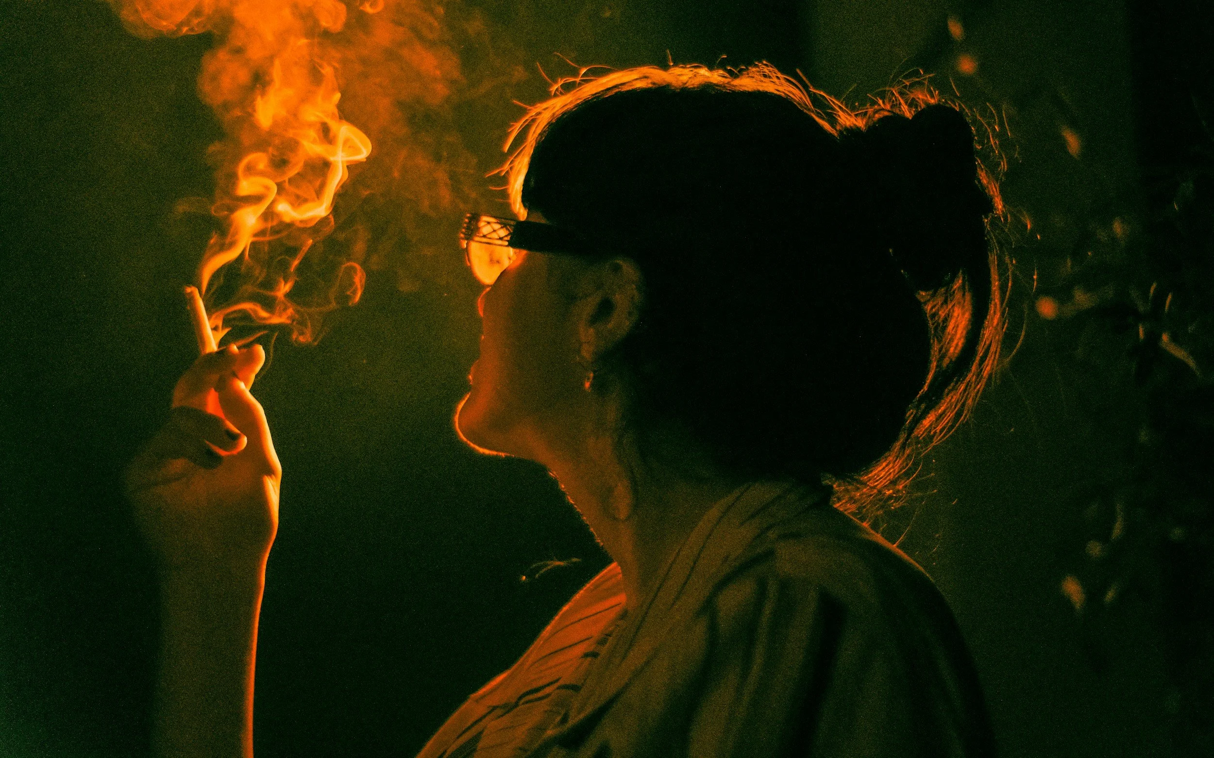 Woman in profile smoking in warm golden light, illustrating why quitting smoking feels like losing a best friend.