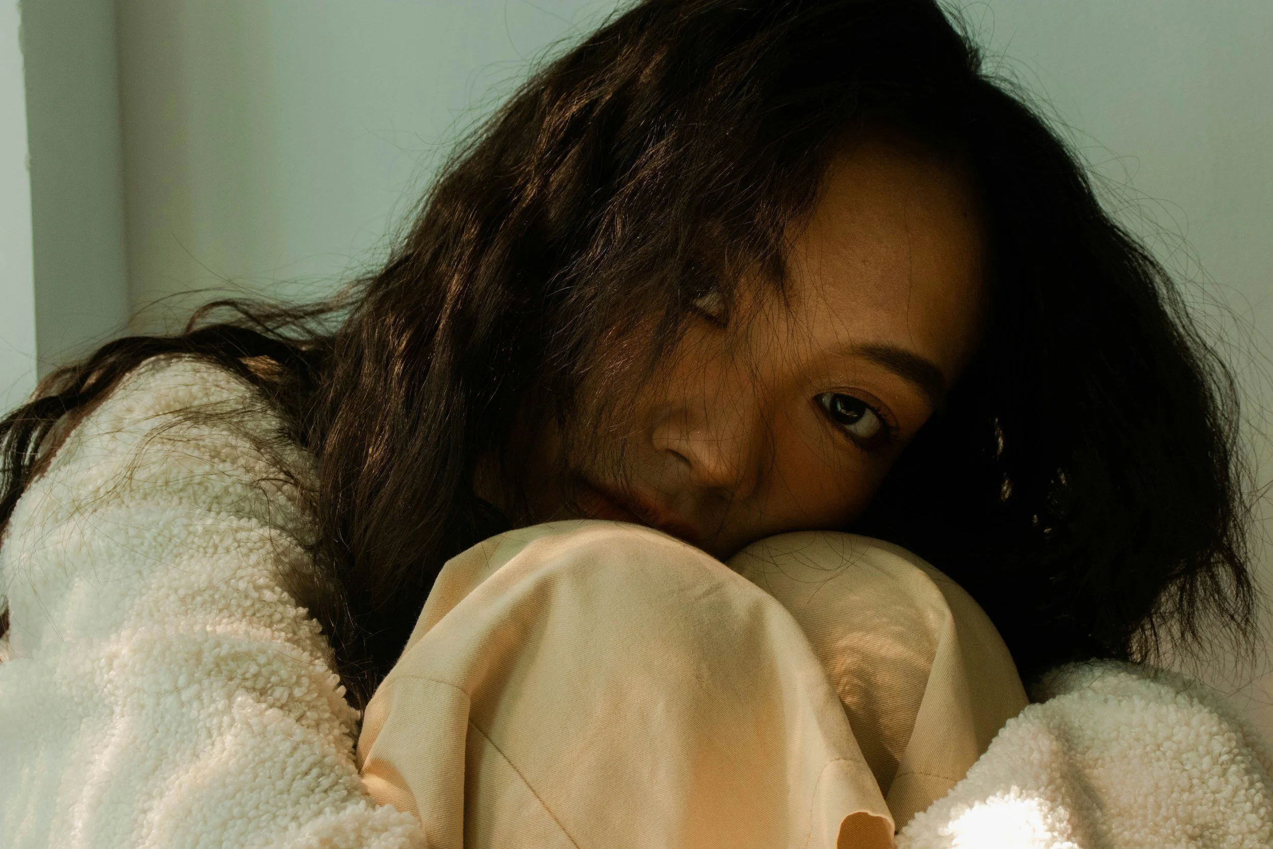 Woman resting her head on her knees seeking comfort, illustrating how smoking has been regulating women's nervous systems.