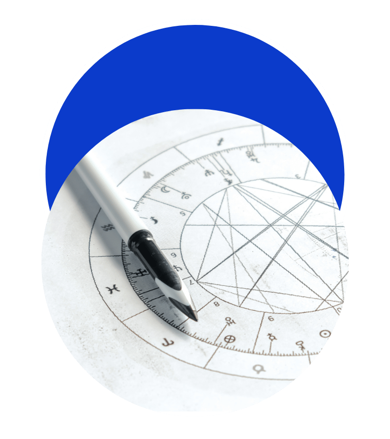 Un marqueur noir et blanc placé sur une roue de papier avec un schéma géométrique et des symboles astrologiques.
