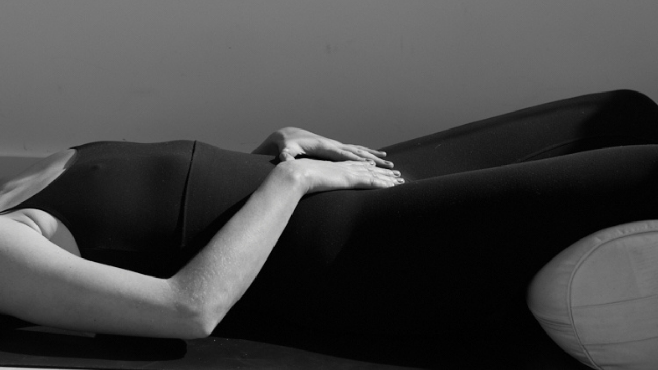 A person lying down on a massage table, receiving a massage, with a focus on their hands and back.