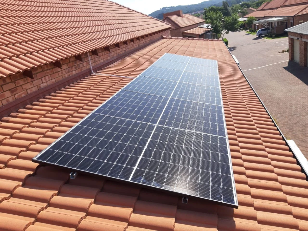 Solar panels installed on a terracotta tiled roof of a residential building.
