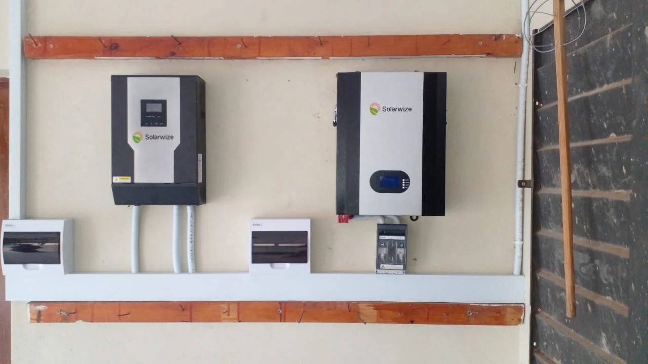 Electric inverter and solar power equipment mounted on a wall with circuit breaker boxes below.
