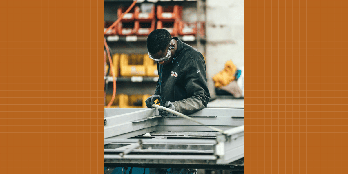 Image of a CTE shop class student about to enter the trades. With a tape measure.