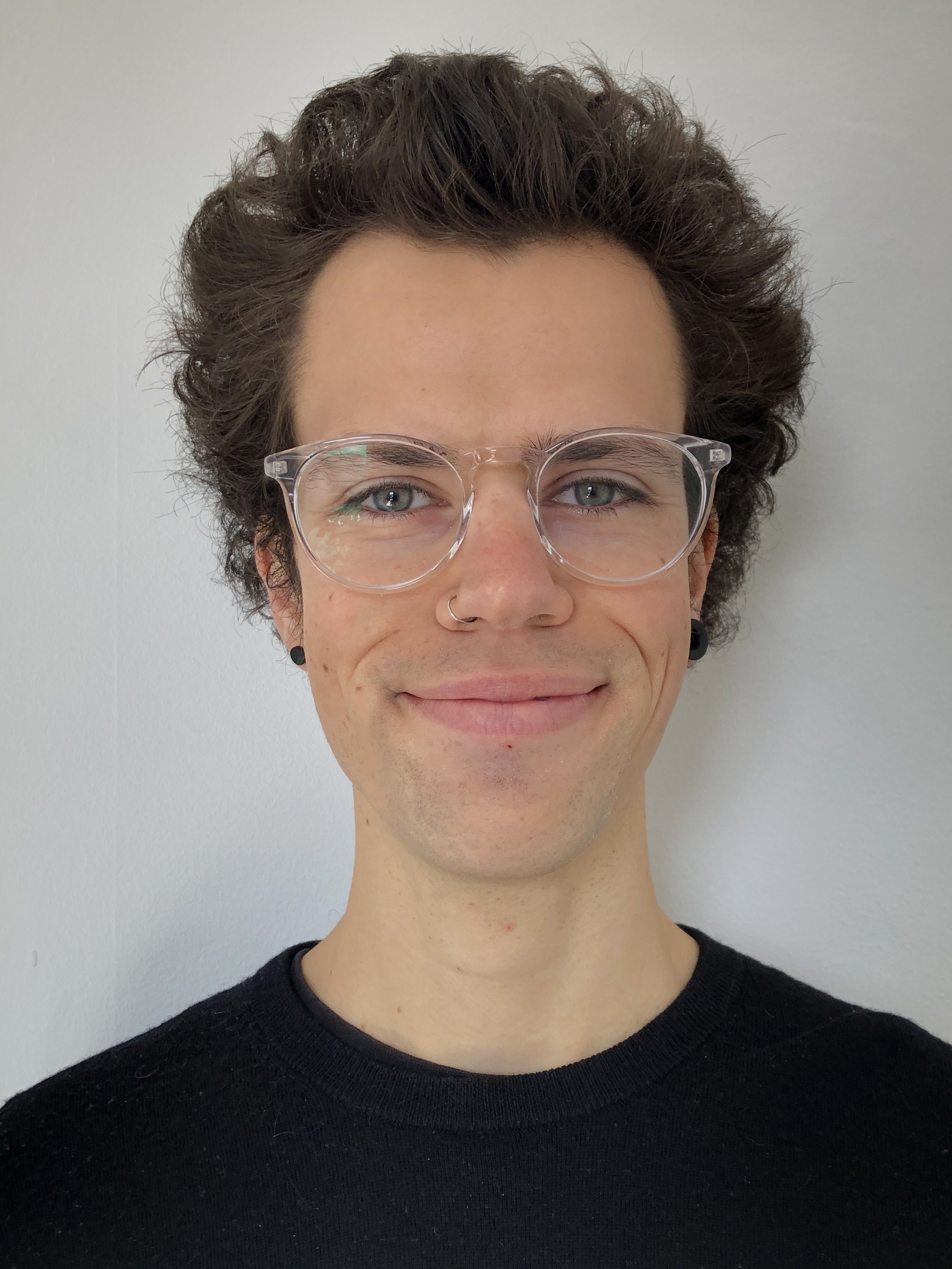 white person with classes curly hair nose piercing