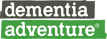 Text reading 'dementia adventure' with 'dementia' in white on a black background and 'adventure' in white on a green background.