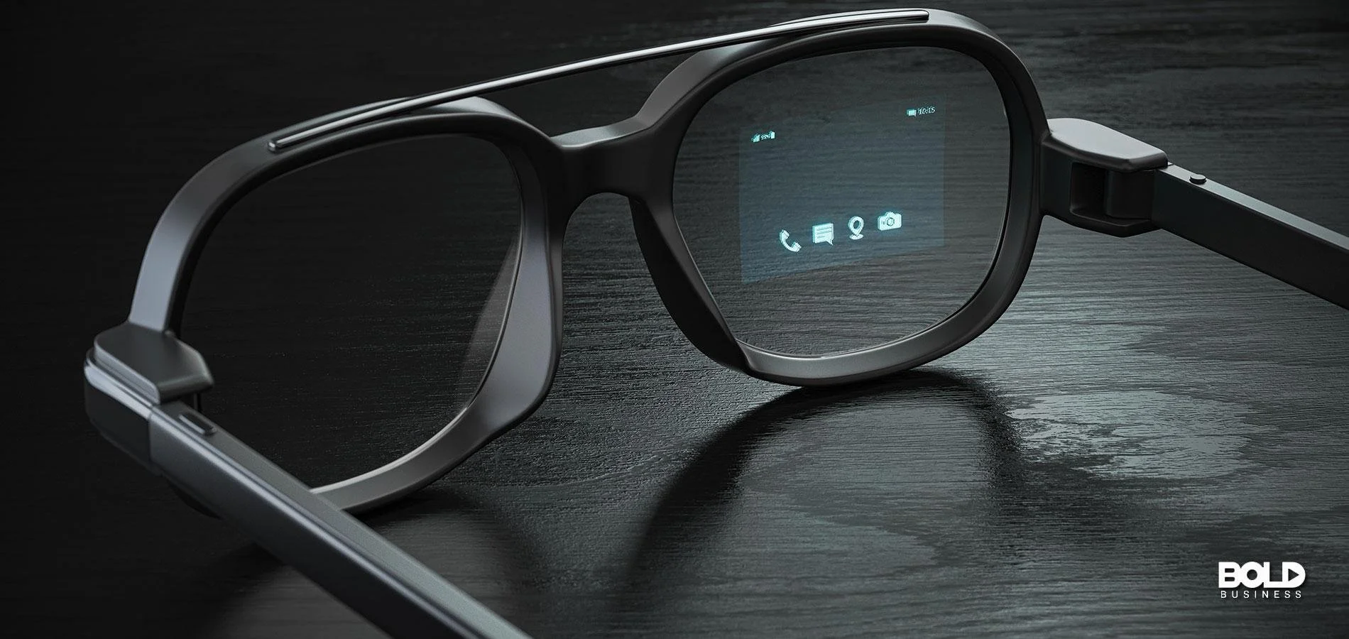 Smart glasses with a transparent screen displaying icons for phone, message, location, and camera, lying on a dark wooden surface.