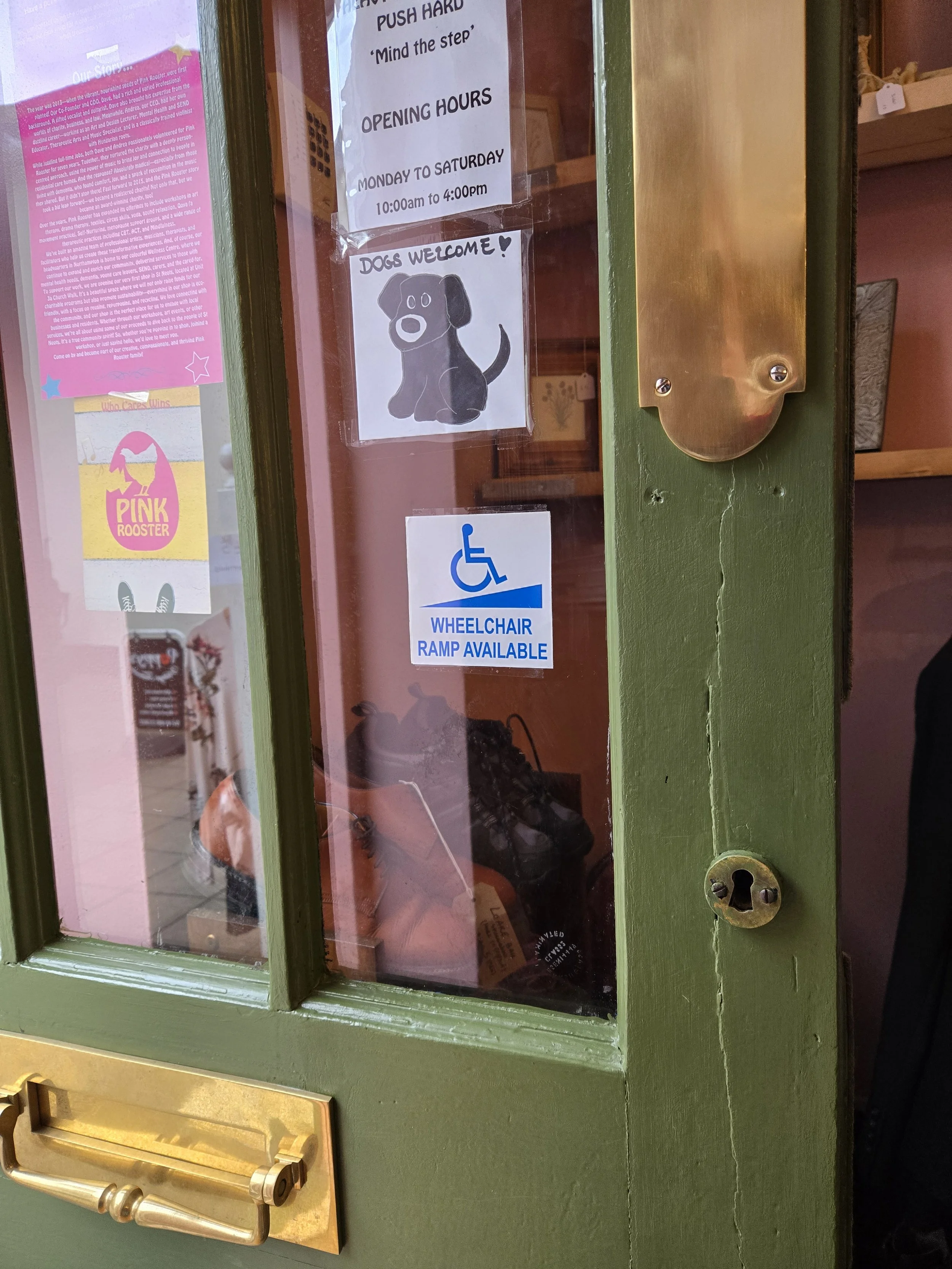 Pink Rooster has a sign and a wireless doorbell and sign at their rear entranve