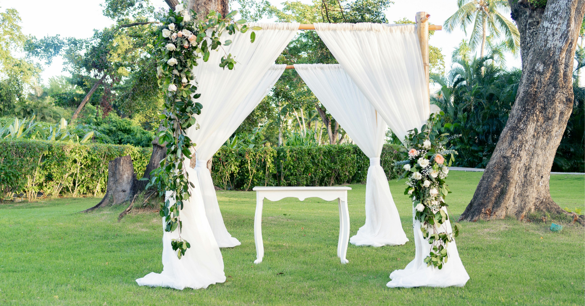 Intimate outdoor wedding setup with floral arch by Promise & Co