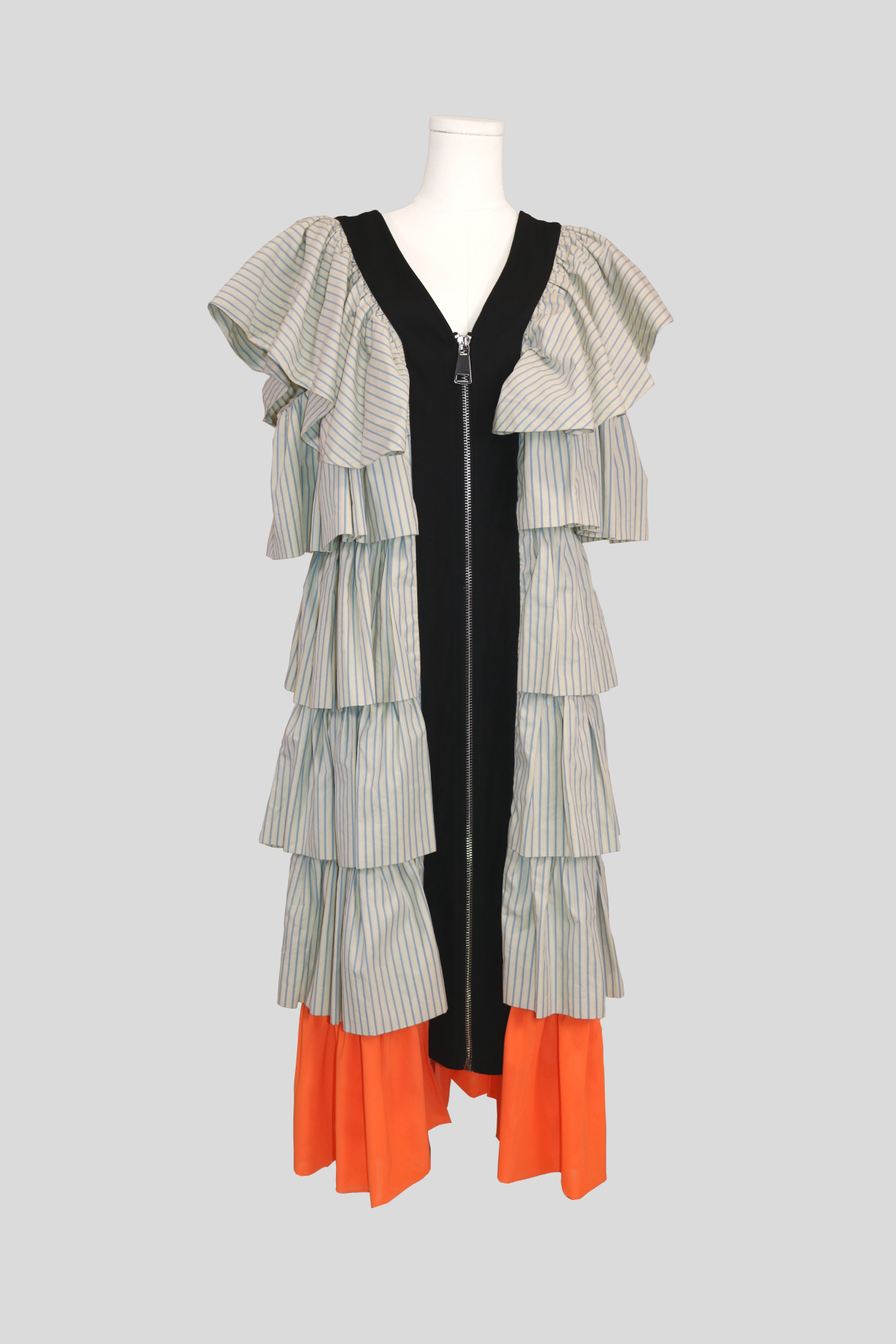 joanne hynes dreamers dress on a dress form featuring a central black zip-front panel. multiple tiers of structured pinstriped frills line the sides and shoulders, finishing with a contrasting bright orange pleated ruffle at the hem.