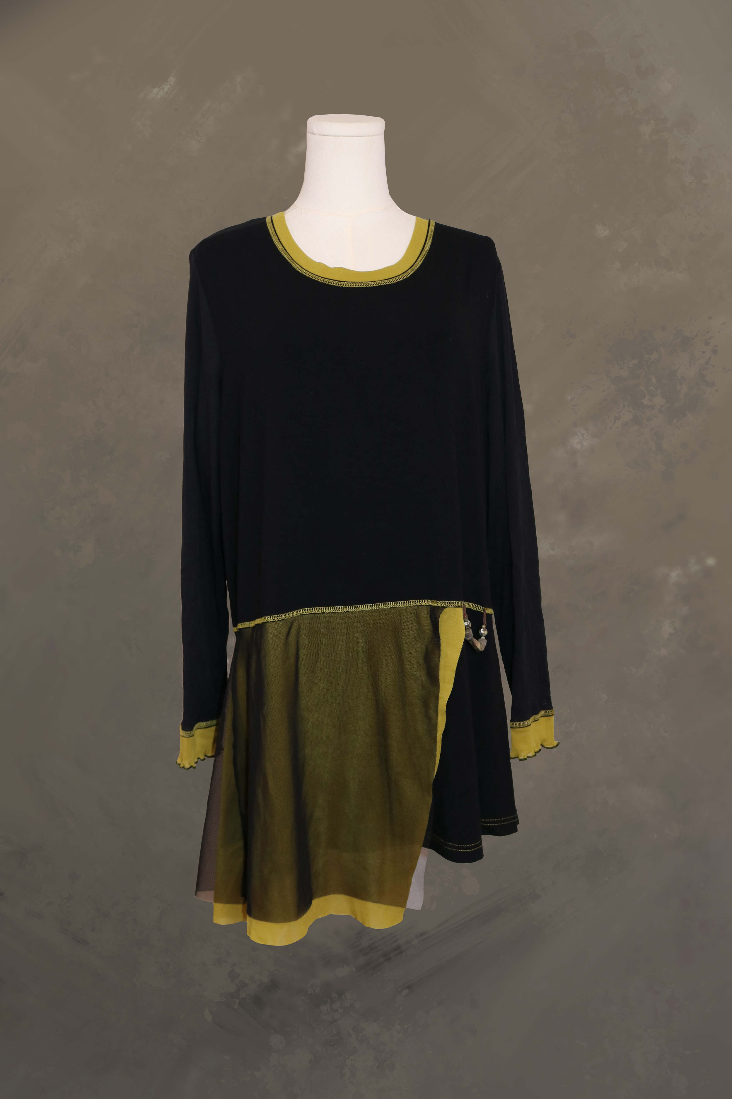 black long-sleeve asymmetrical tunic by fred sabatier on a dress form. features an olive green crew neckline, a sheer olive green mesh drop-waist skirt panels, and contrast stitching along the seams and cuffs.