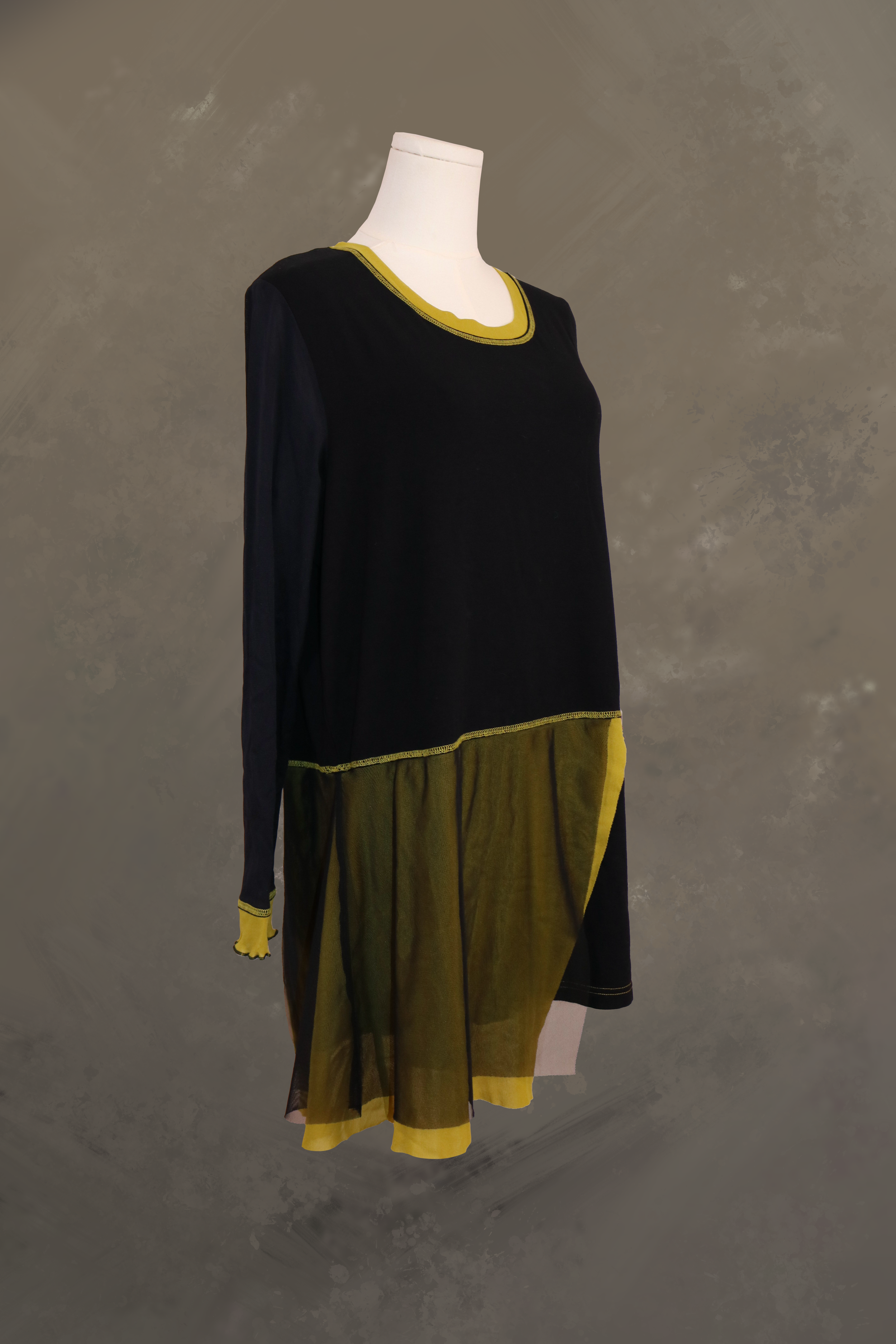 profile view of the black fred sabatier asymmetrical tunic. highlights the layered drape of the sheer olive green mesh panels along the hem and the elongated, structured line of the long black sleeves.
