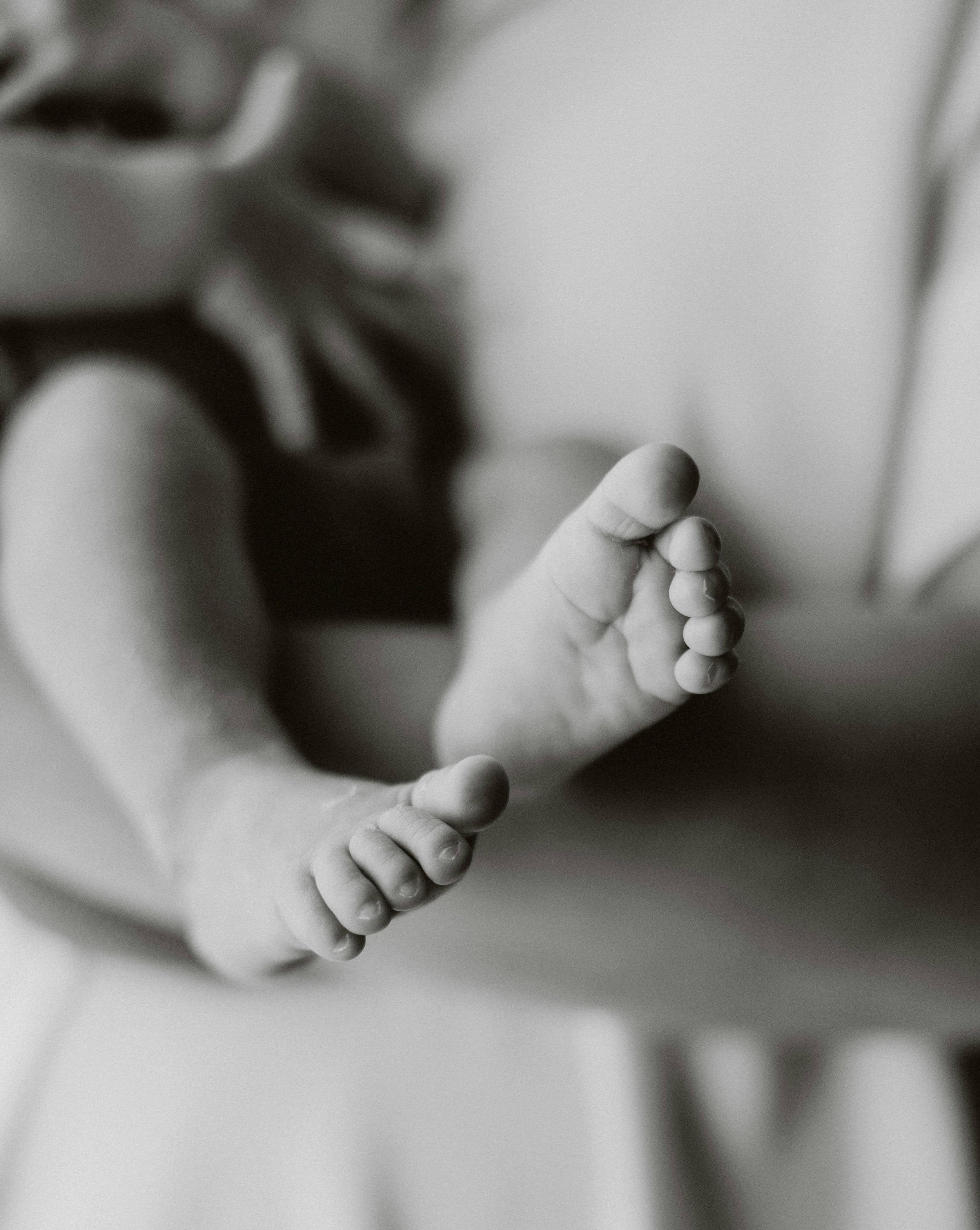 A newborn baby's toes in a Santa Clara hospital after their mother gave birth with help from a Flourish & Flow full spectrum doula.