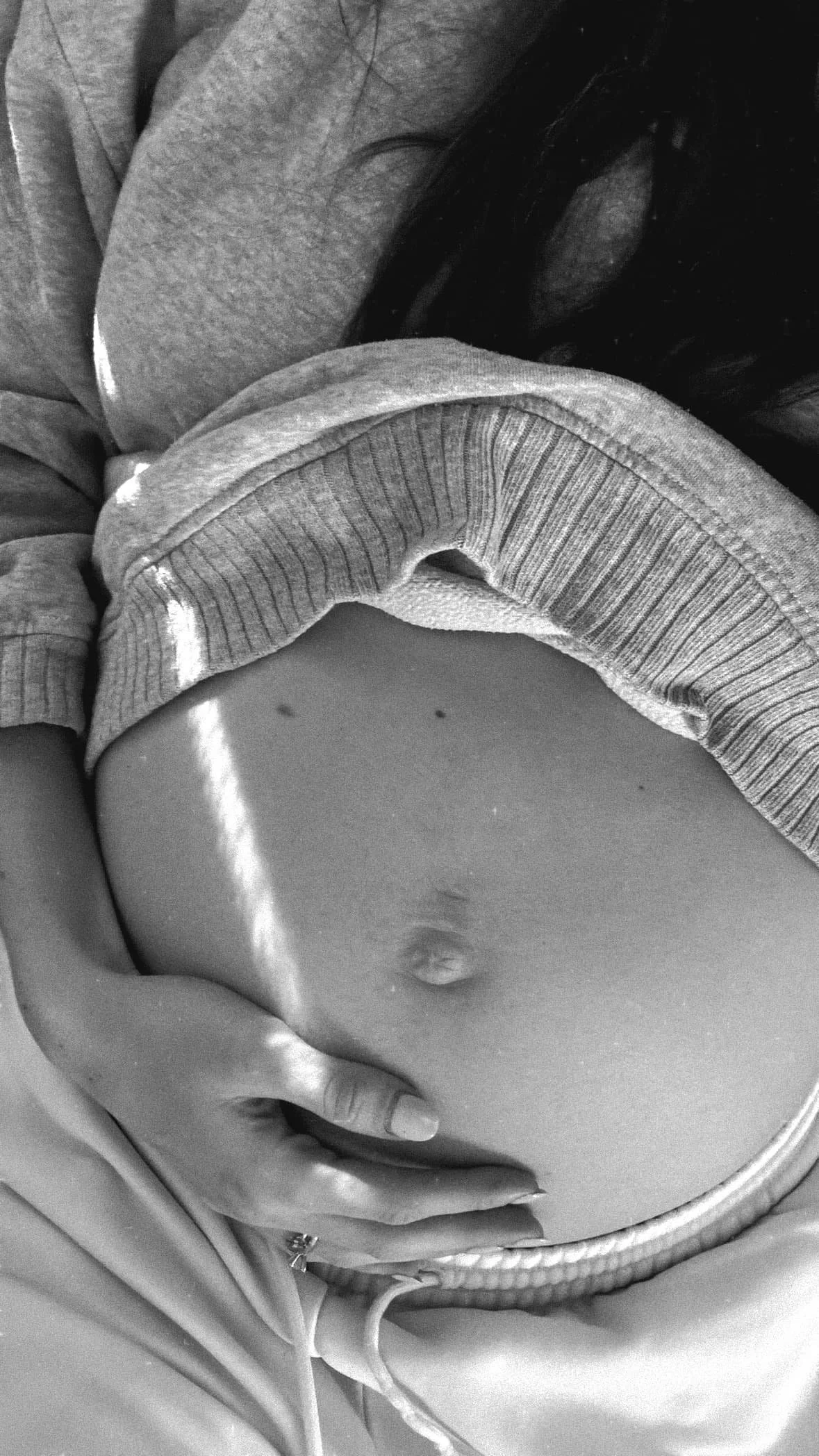 A pregnant woman, who is working with birth doula Jamee Leann Vasquez in the South Bay Area, poses with her stomach.