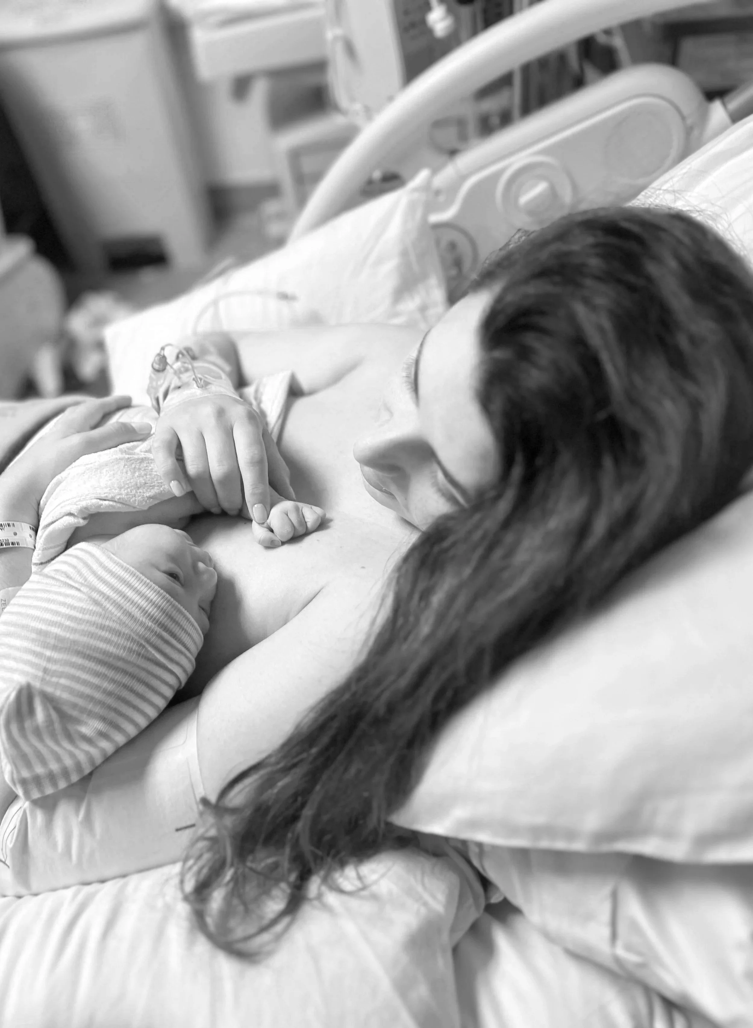 A mother, who is receiving lactation and sleep coaching from Flourish & Flow, holds her newborn