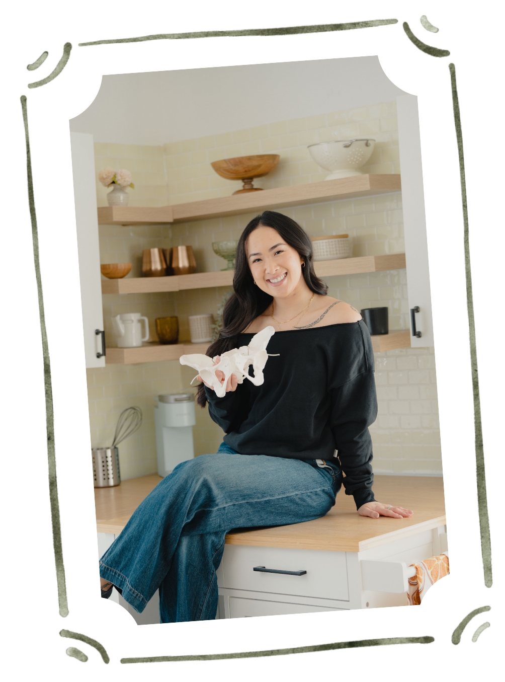 Founder of Flourish & Flow, Jamee Leann Vasquez poses with a pelvis model in a Redwood City kitchen.