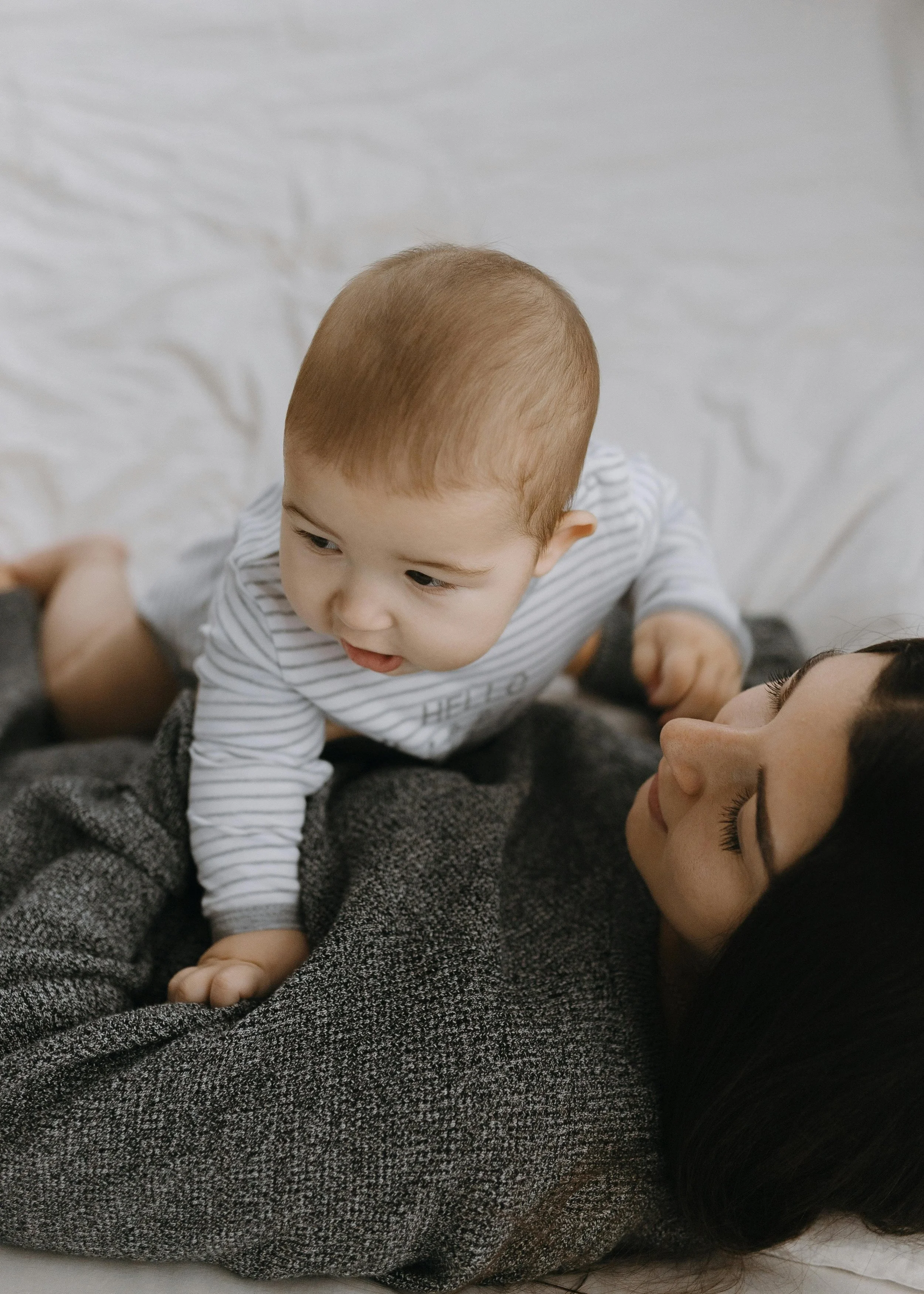 A baby lays on his mother in Los Gatos, California after their daytime postpartum doula from Flourish & Flow has left for the day.