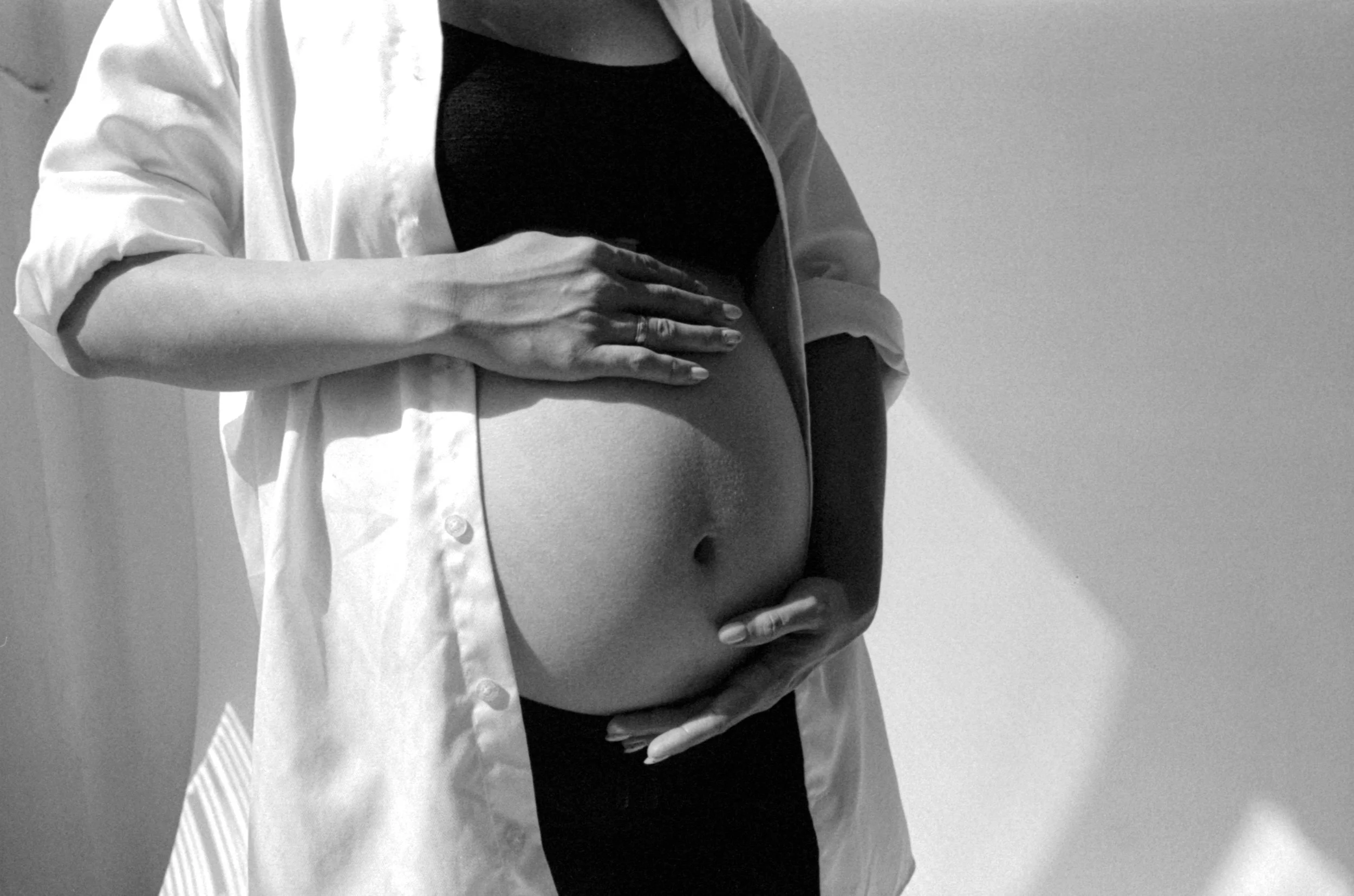 A pregnant woman holds her stomach during a prenatal yoga session with Flourish & Flow in the South Bay Area.