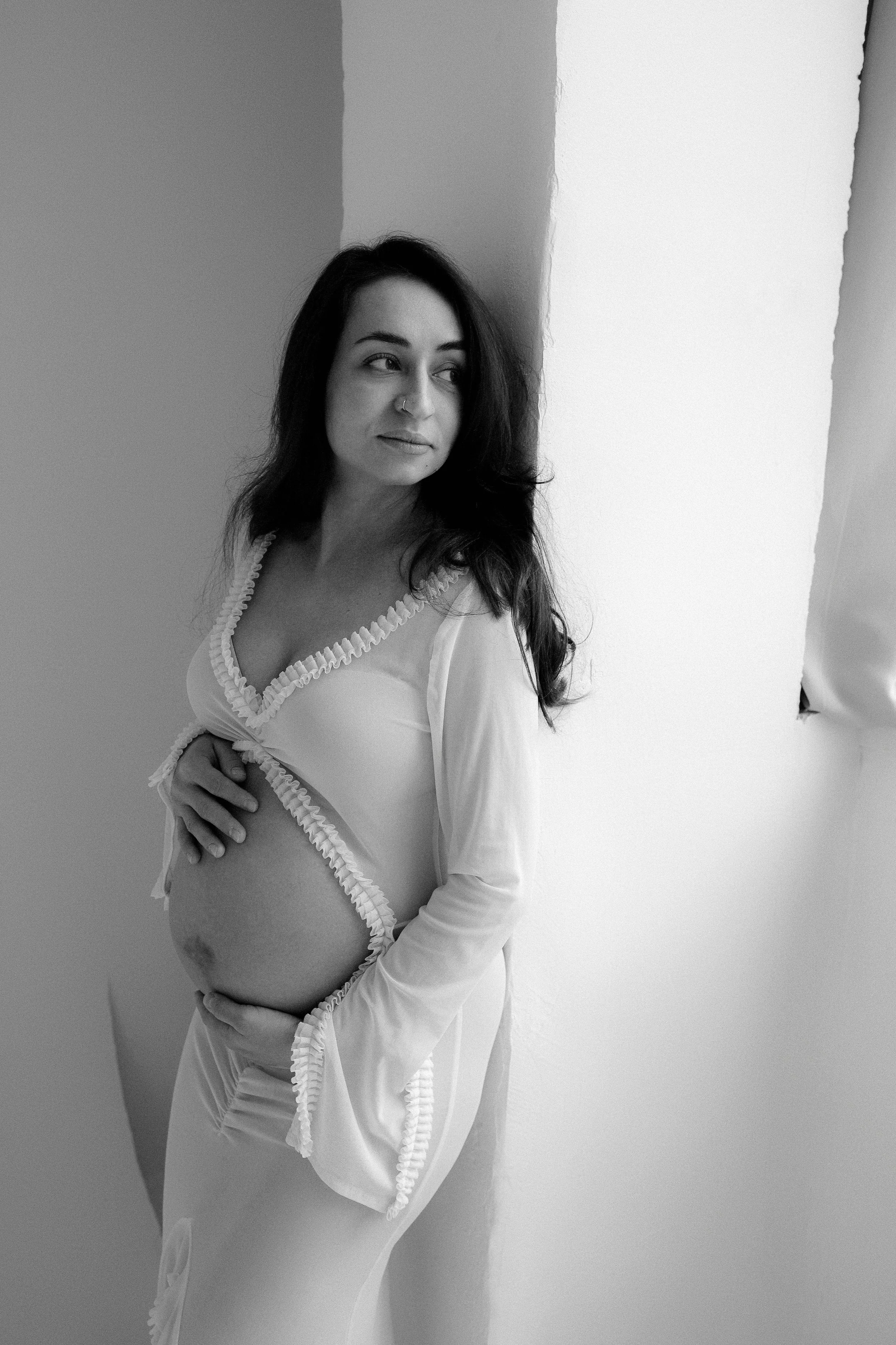 A birth doula client with Flourish & Flow holds her pregnant stomach in Santa Clara, Claifornia.