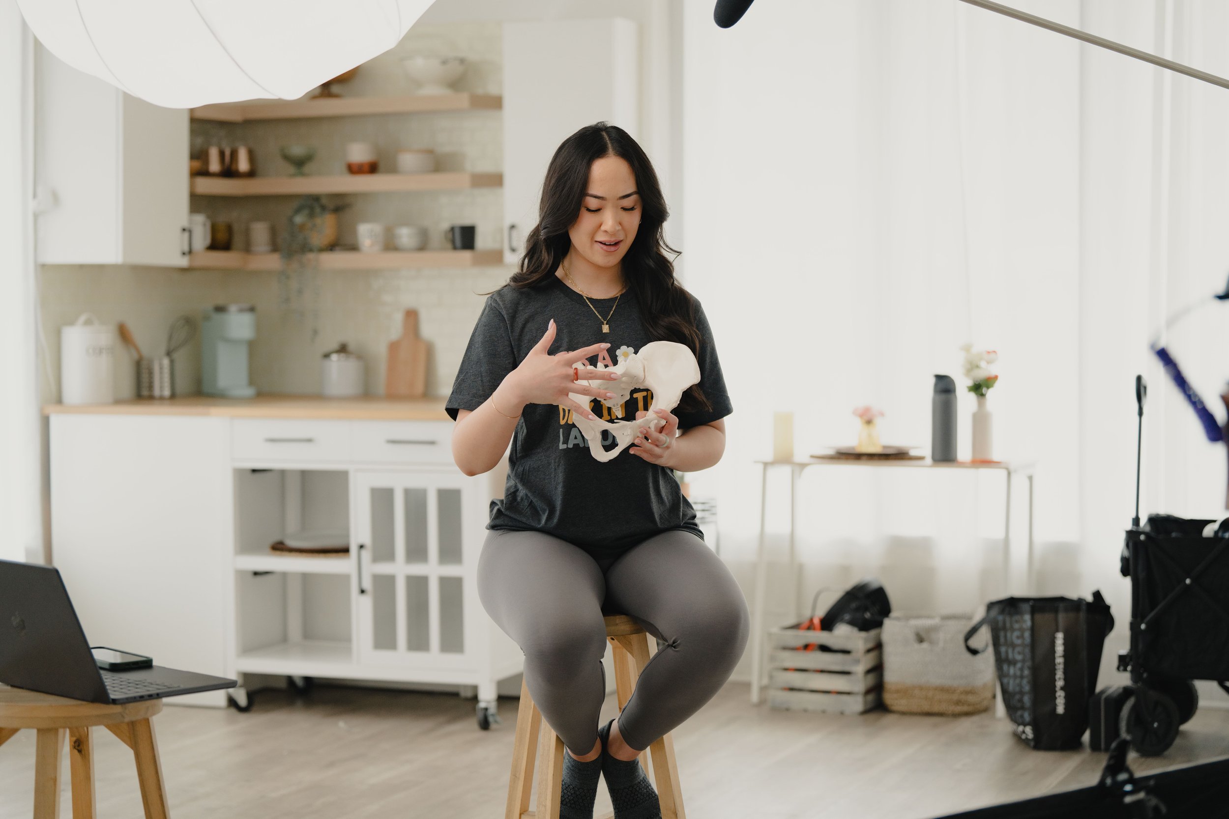 Full spectrum doula Jamee Leann Vasquez discusses her birth and postpartum services while holding a pelvis model.