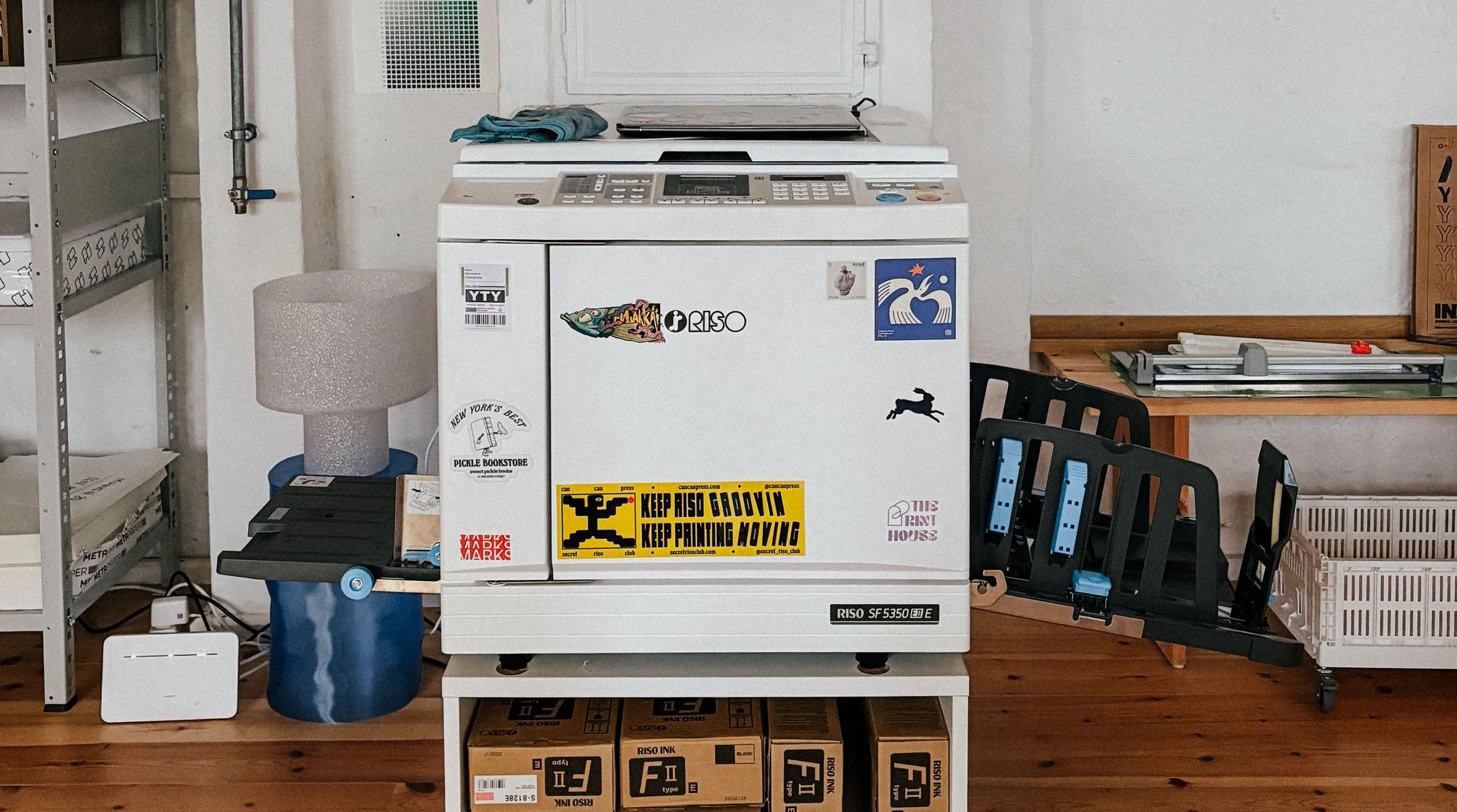 A riso printer stands on wooden floor