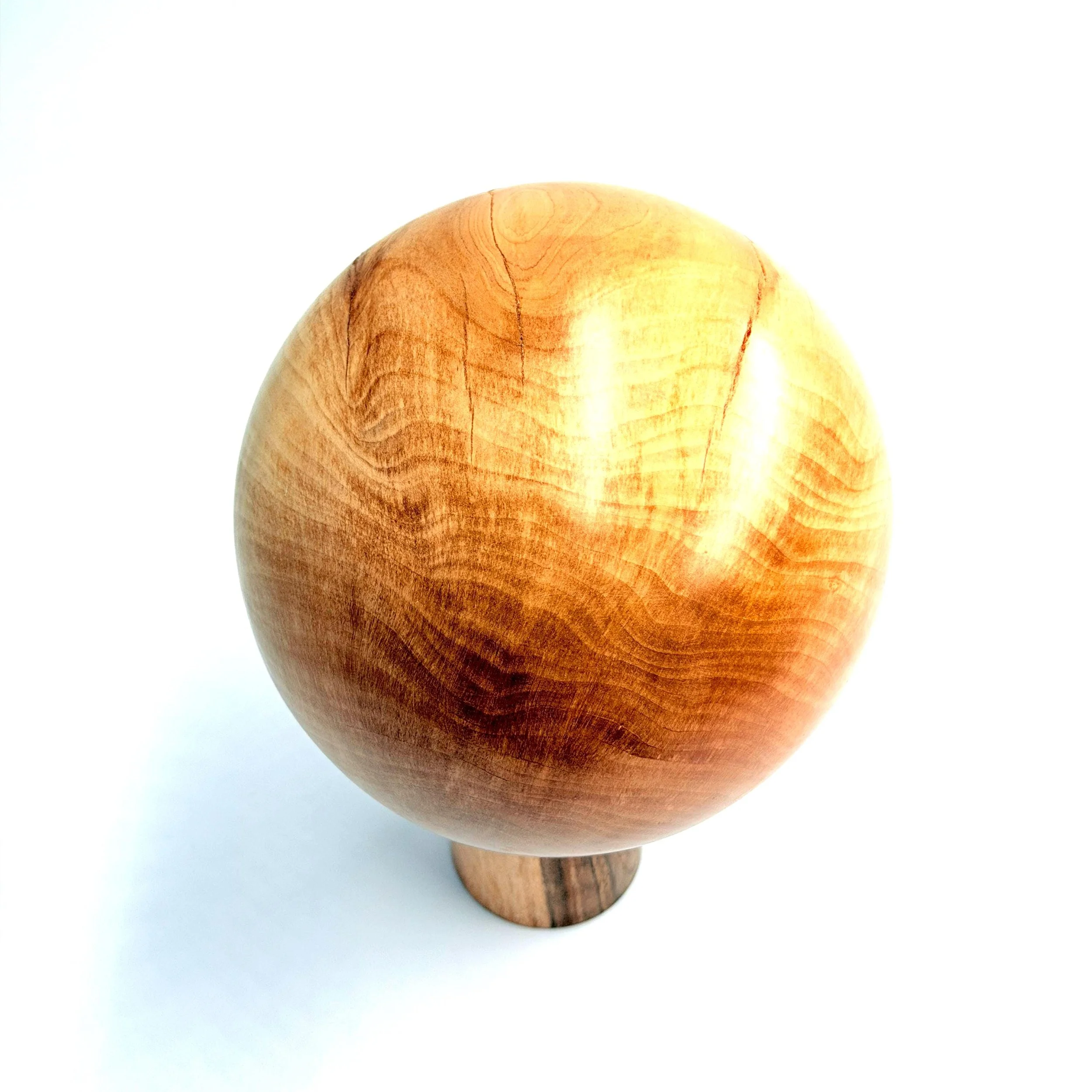 Obenansicht einer massiven Birnenholz‑Kugel mit seidig geölter Oberfläche