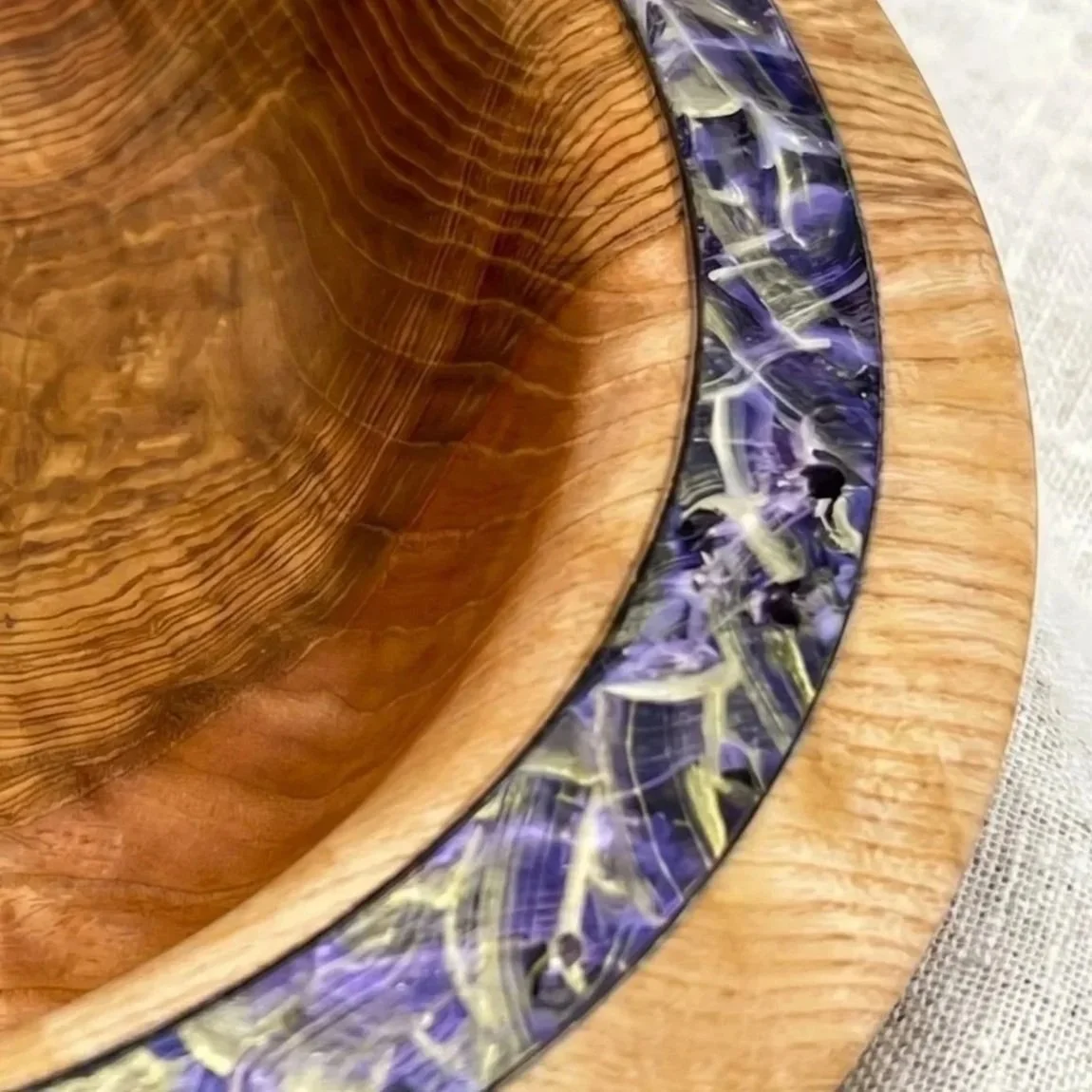 Handgefertigte Holzschale aus österreichischem Holz mit einzigartiger Maserung und dekorativer farbiger Einlage – Detailansicht eines Unikats.