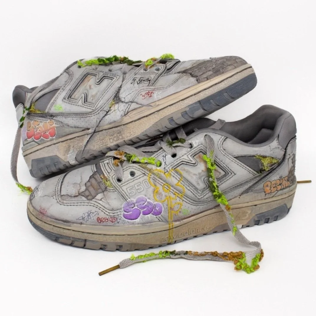 Worn and distressed sneakers with graffiti art and moss accents