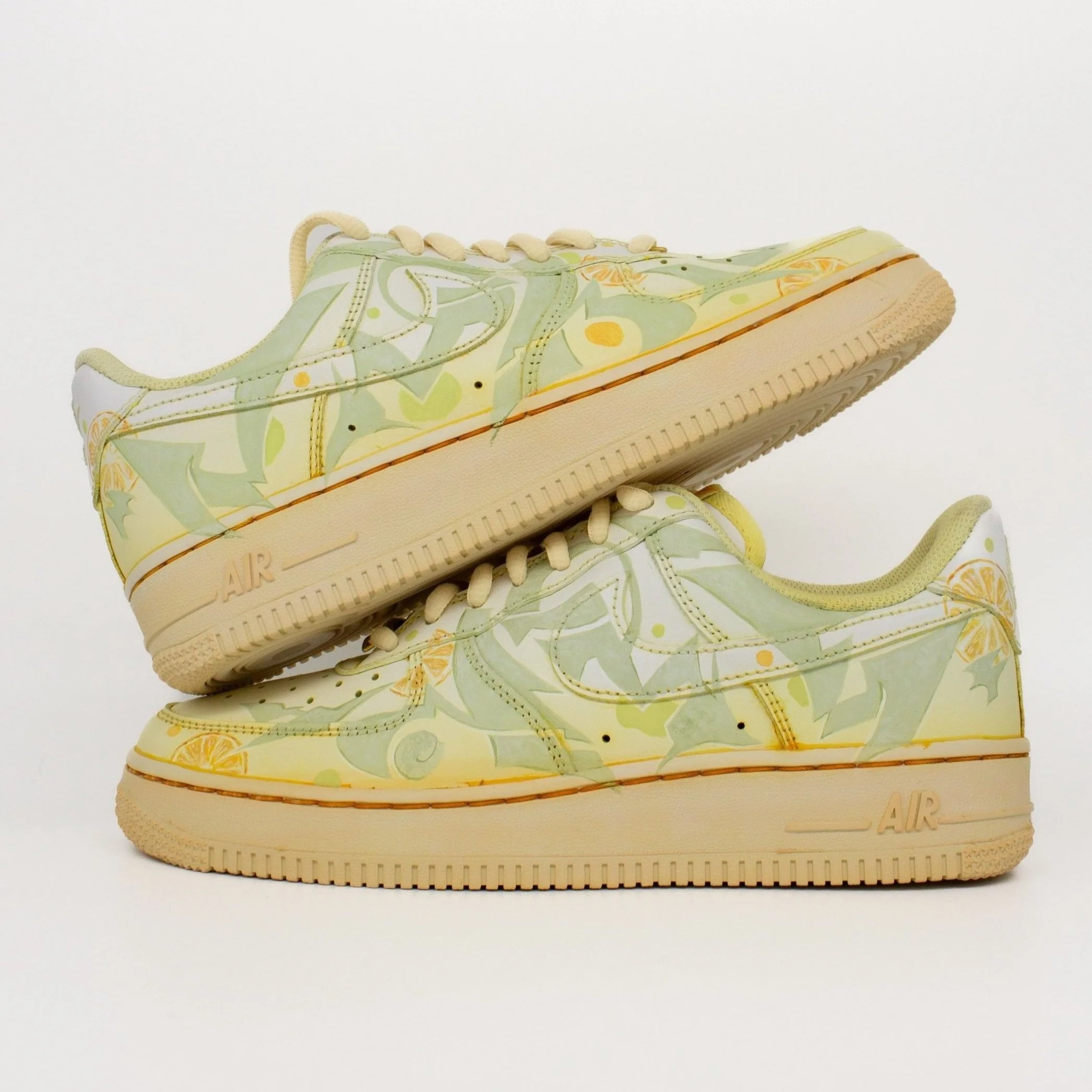 A pair of sneakers with a green and yellow abstract graffiti design.