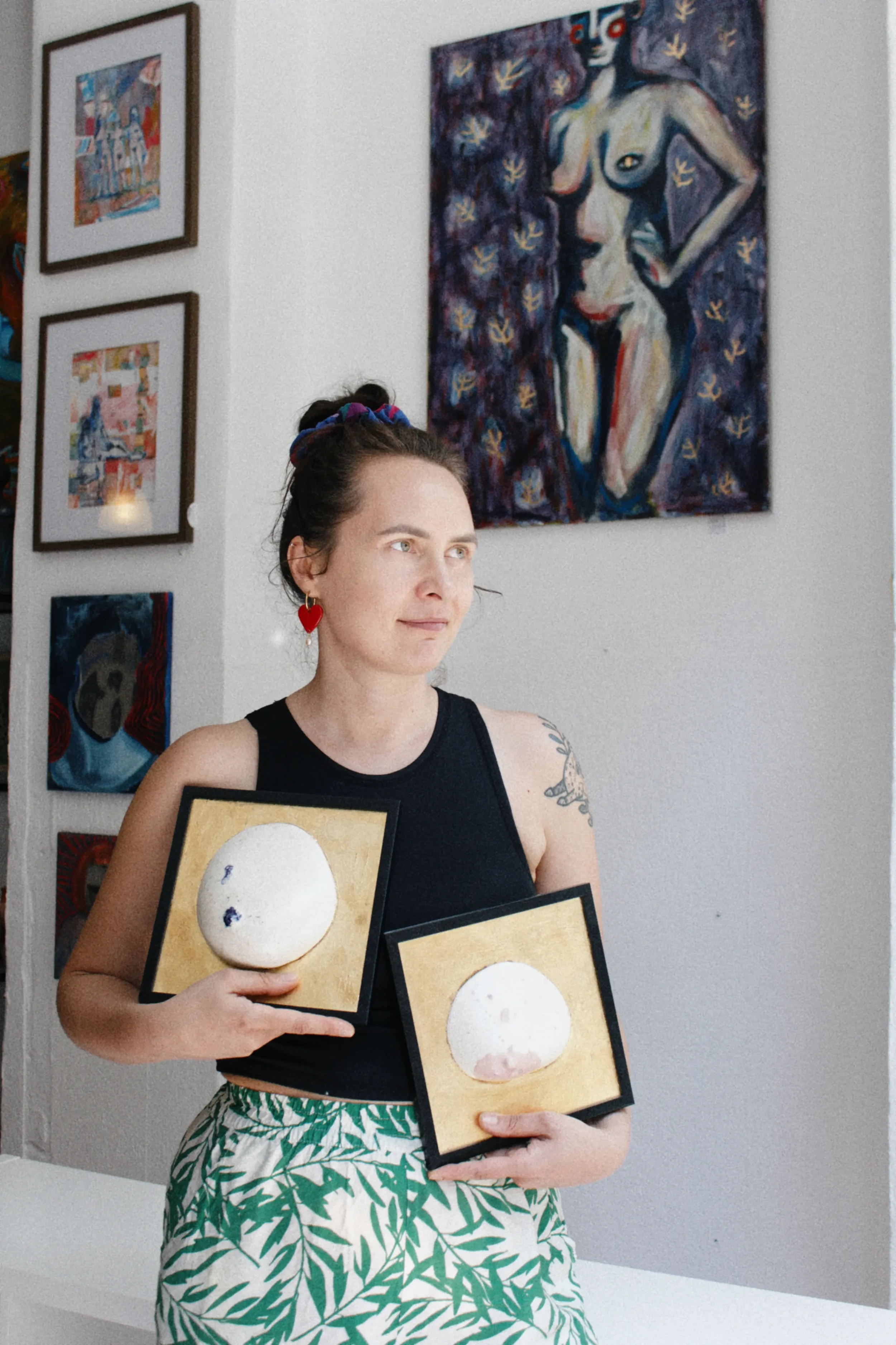 Founder of Marti Ceramic Studio presenting handmade ceramic pieces from her collection