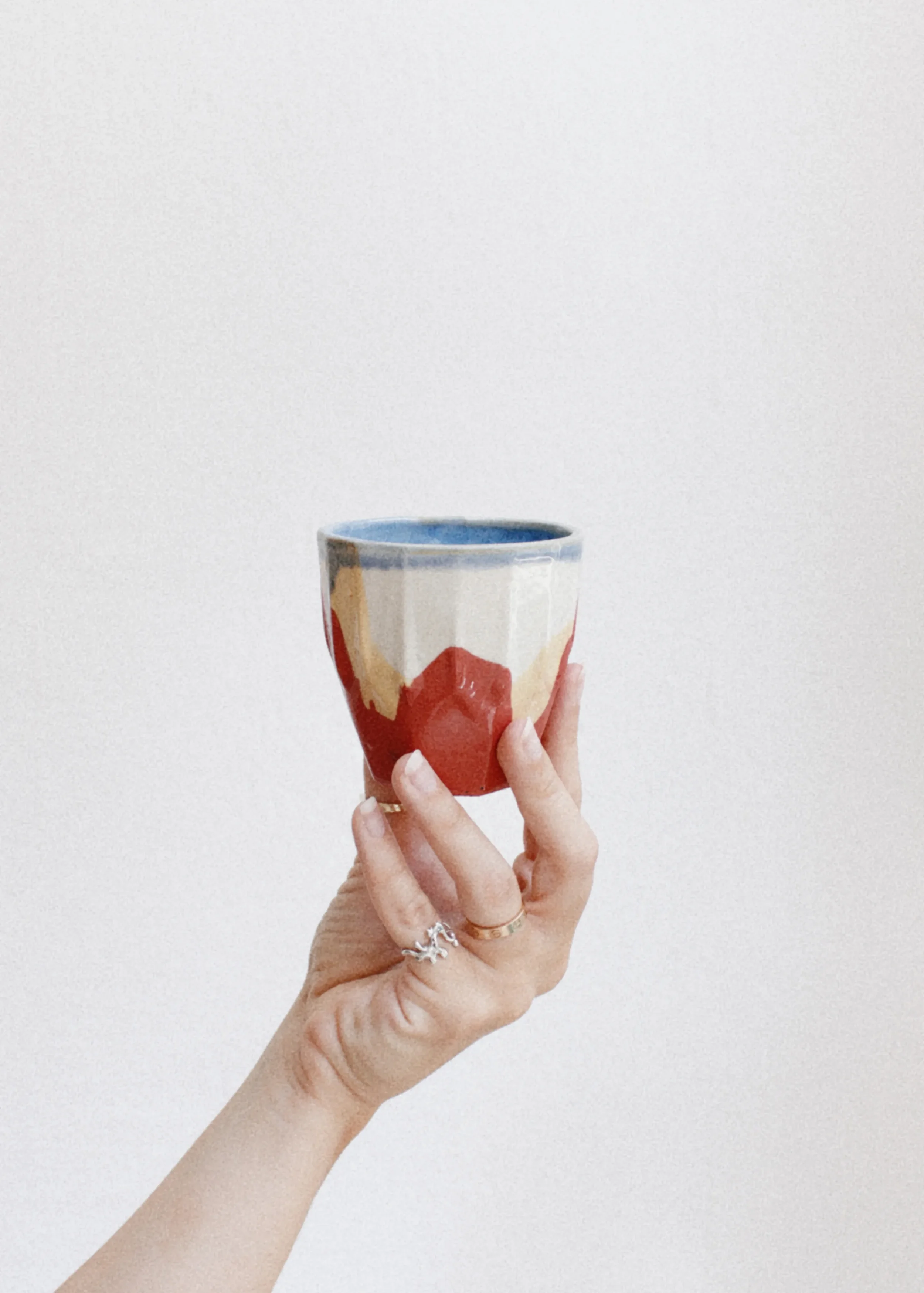 Hand holding a handmade ceramic cup created by Marti Ceramic Studio