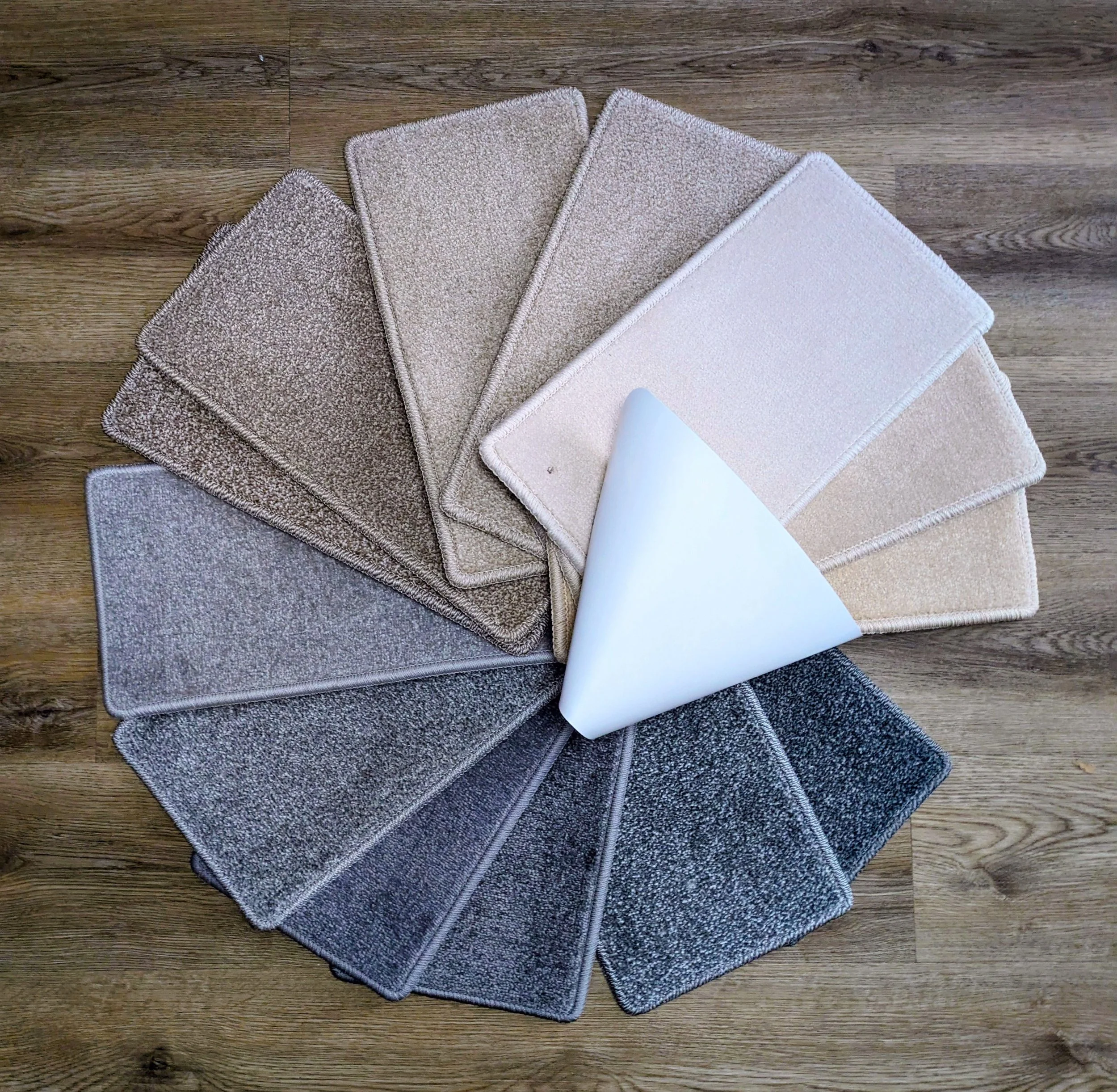 A collection of various beige and grey carpet samples.