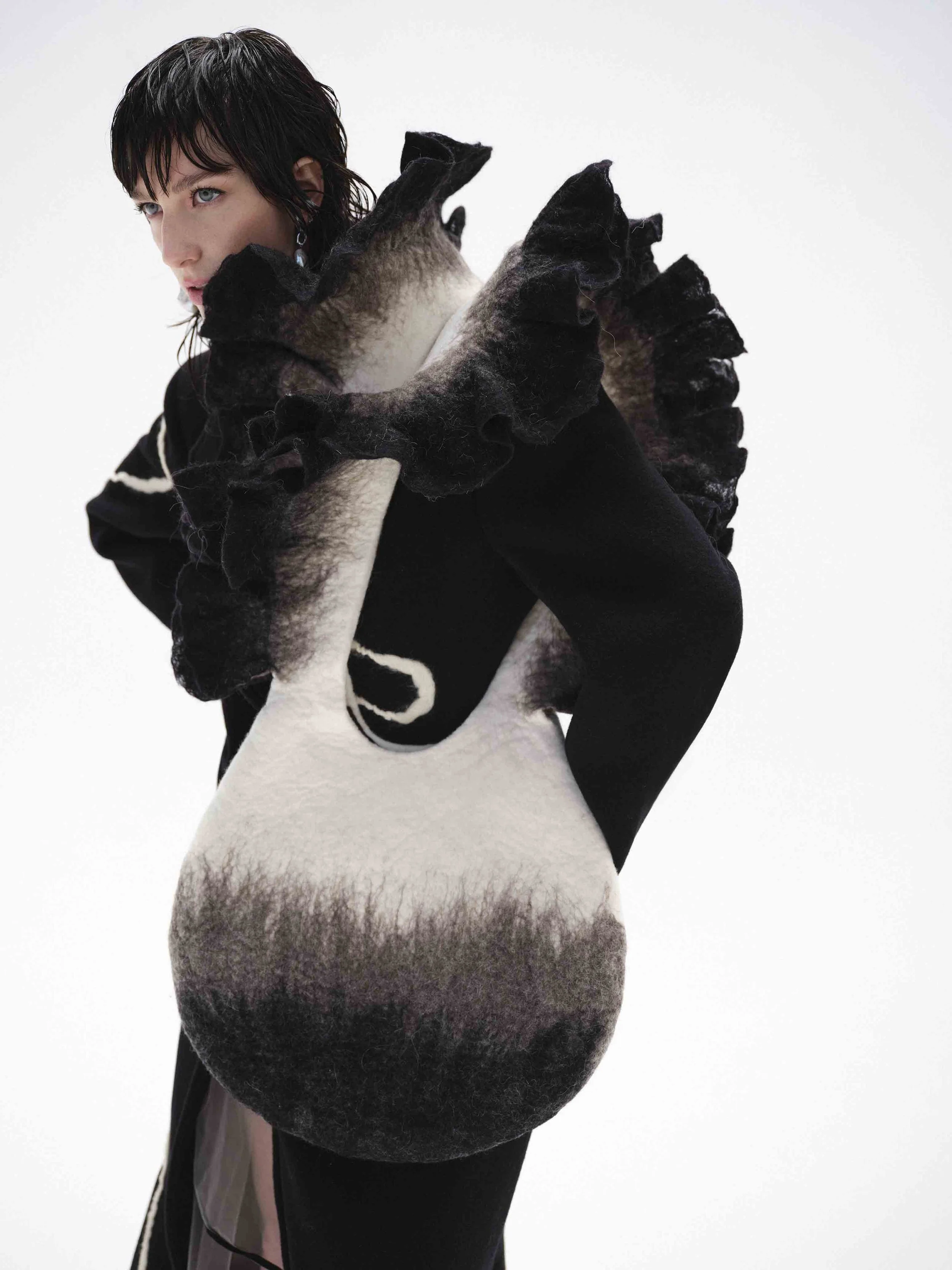 Person wearing an avant-garde black and white outfit with ruffled details