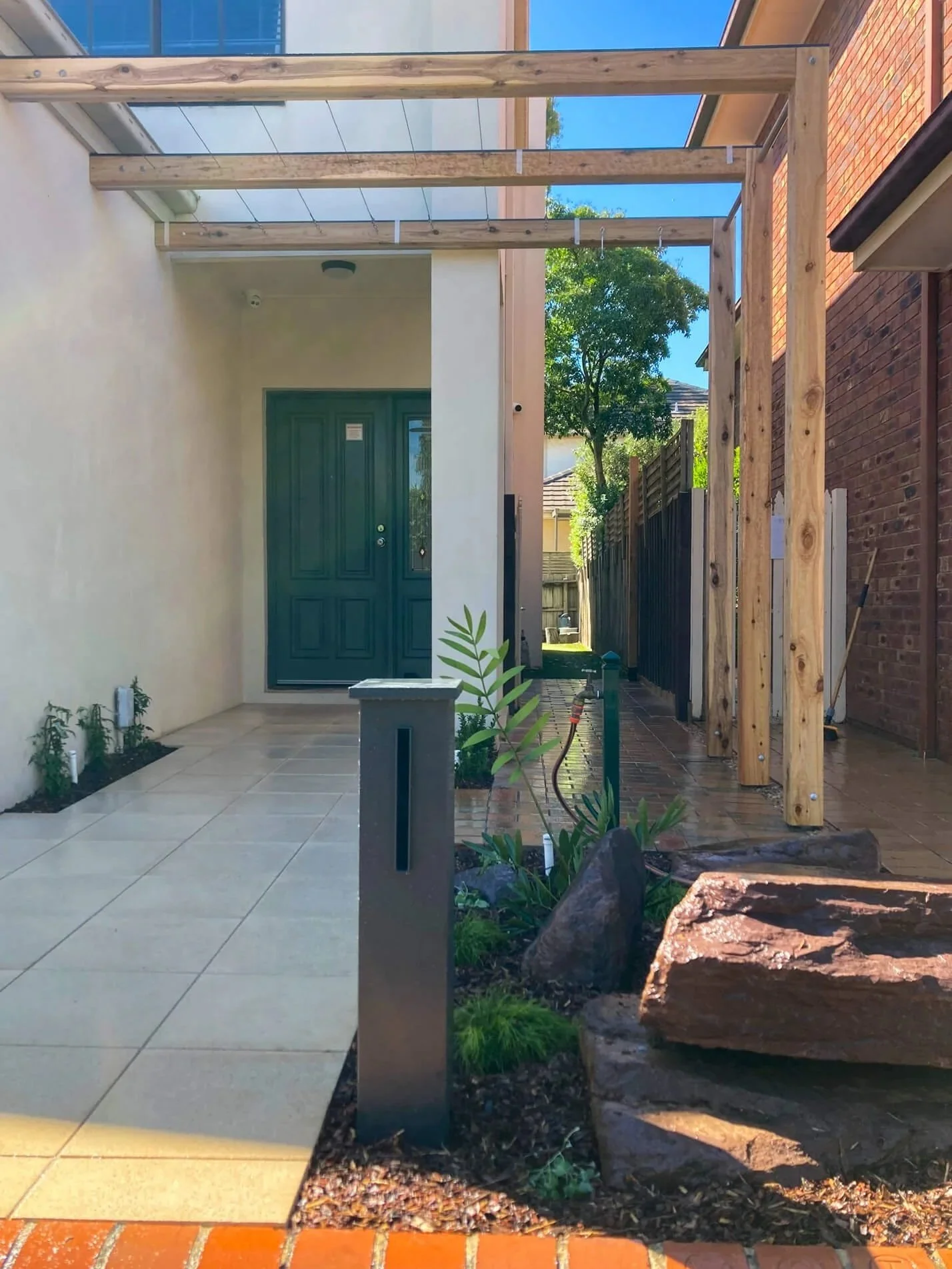 Modern front entry remodel with pergola and paving