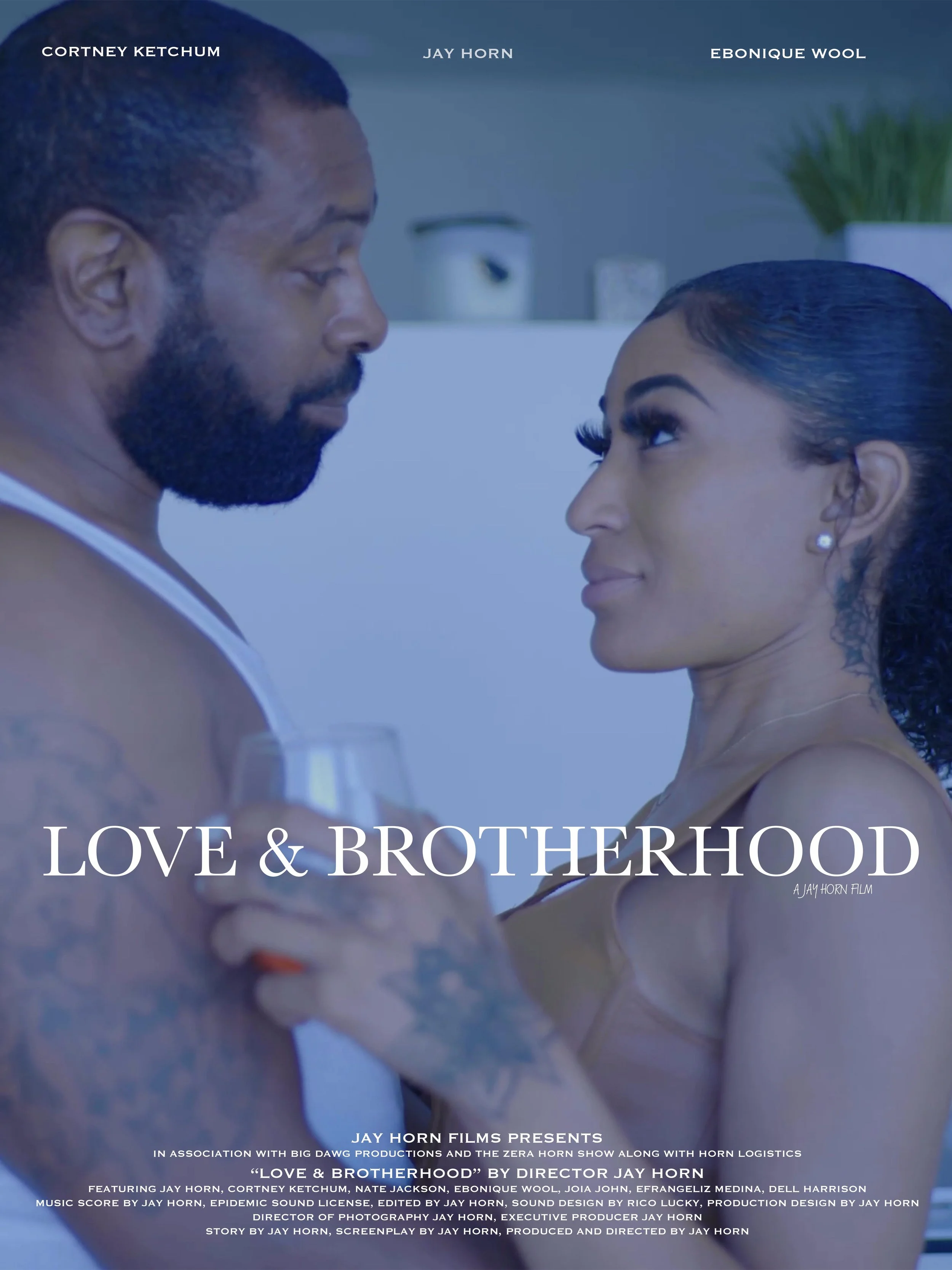 Two people facing each other closely, a man with a beard and a woman with dark hair and earrings, in a scene from the film 'Love & Brotherhood' by Jay Horn.