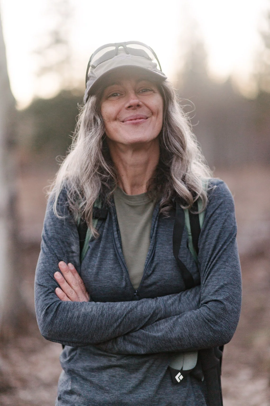 Andrea Broglio smiling with arms crossed in the forest