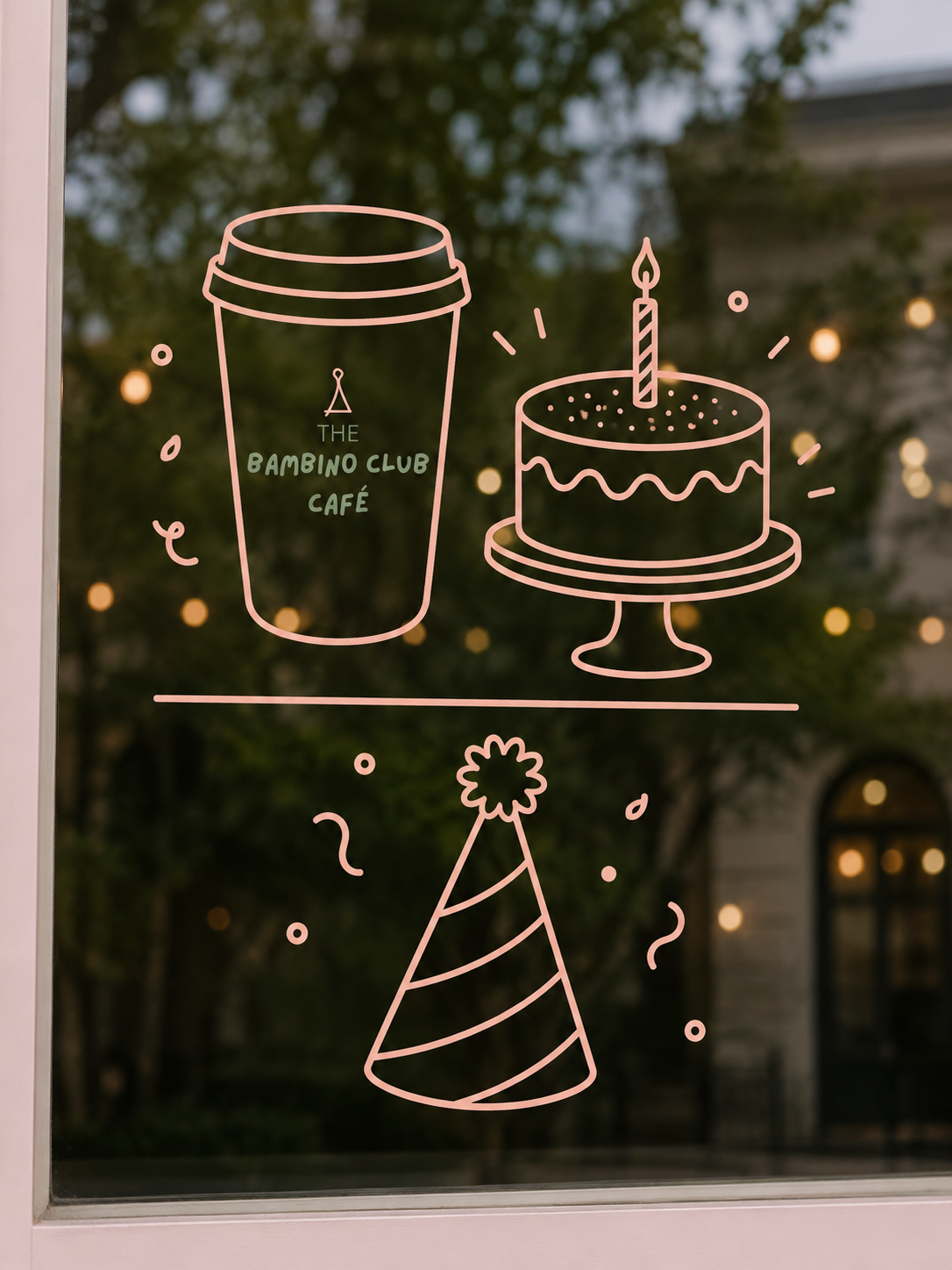 Decorative window sticker with line drawings of a coffee cup, birthday cake with a lit candle, and a party hat, for a celebration at The Bambino Club Café.