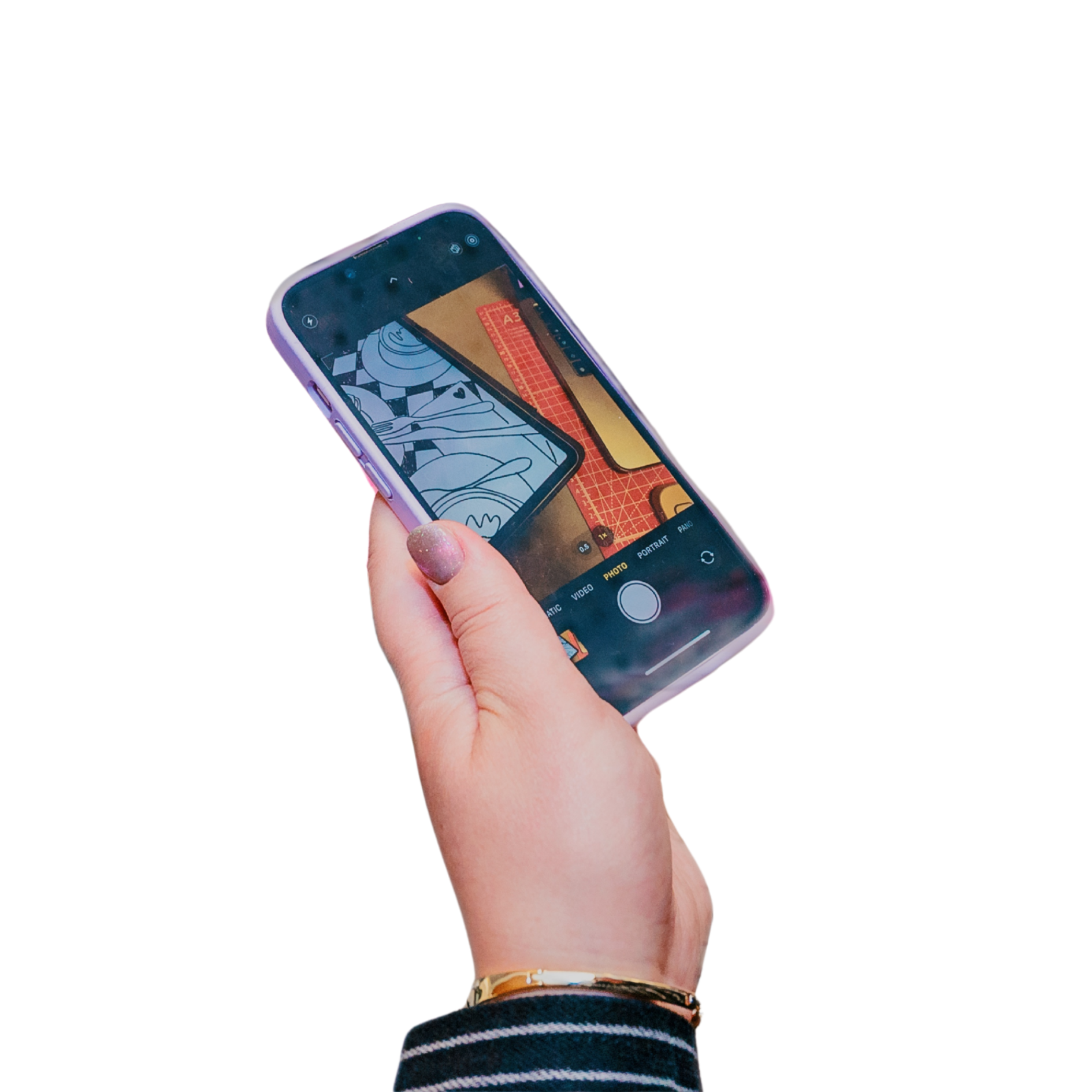 Close-up of a person's hand holding a smartphone, capturing a photo of an art piece and a red card on a table.
