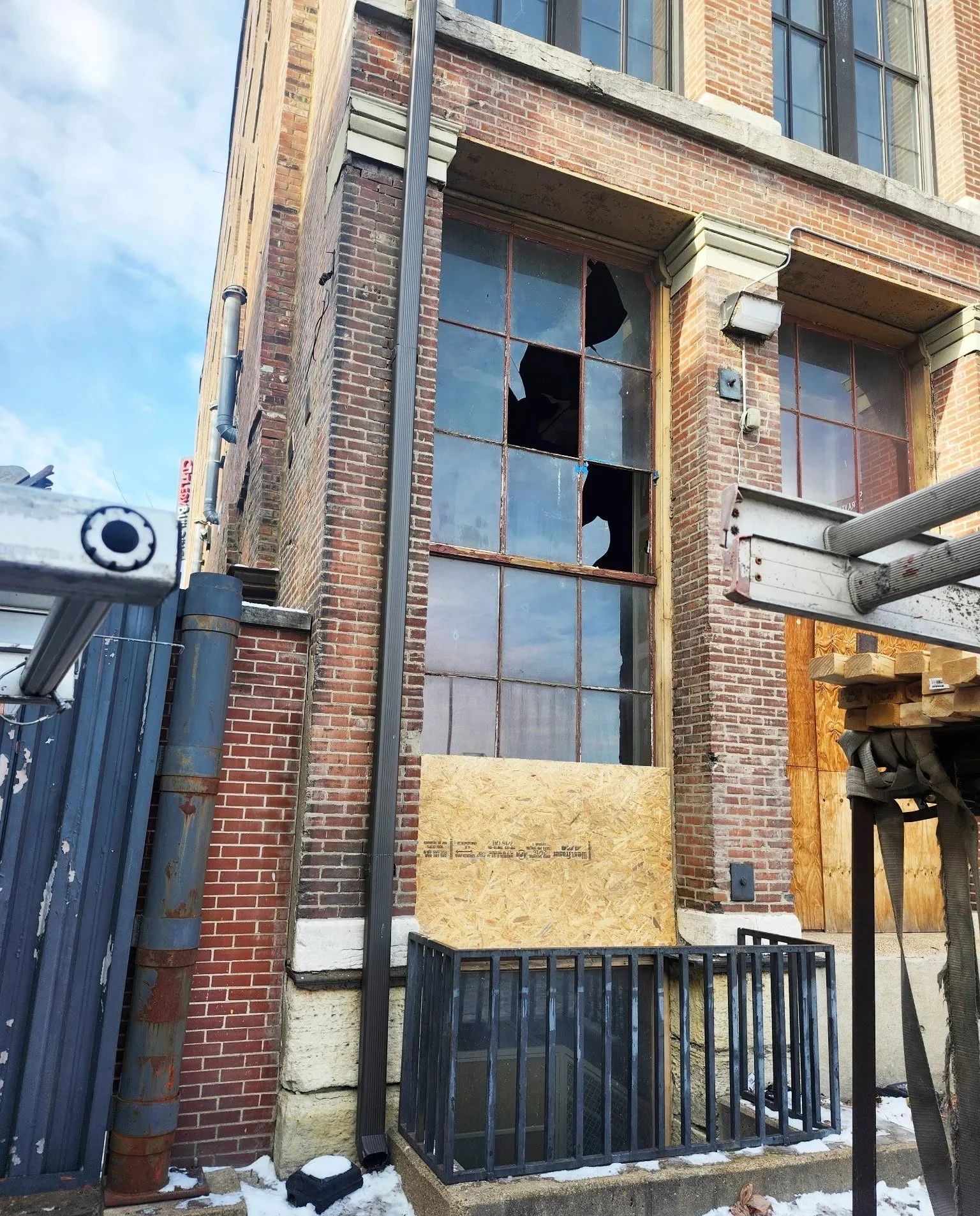 A brick building with broken windows, plywood covering window board up provided by The Board Up Company in St. Louis, Missouri