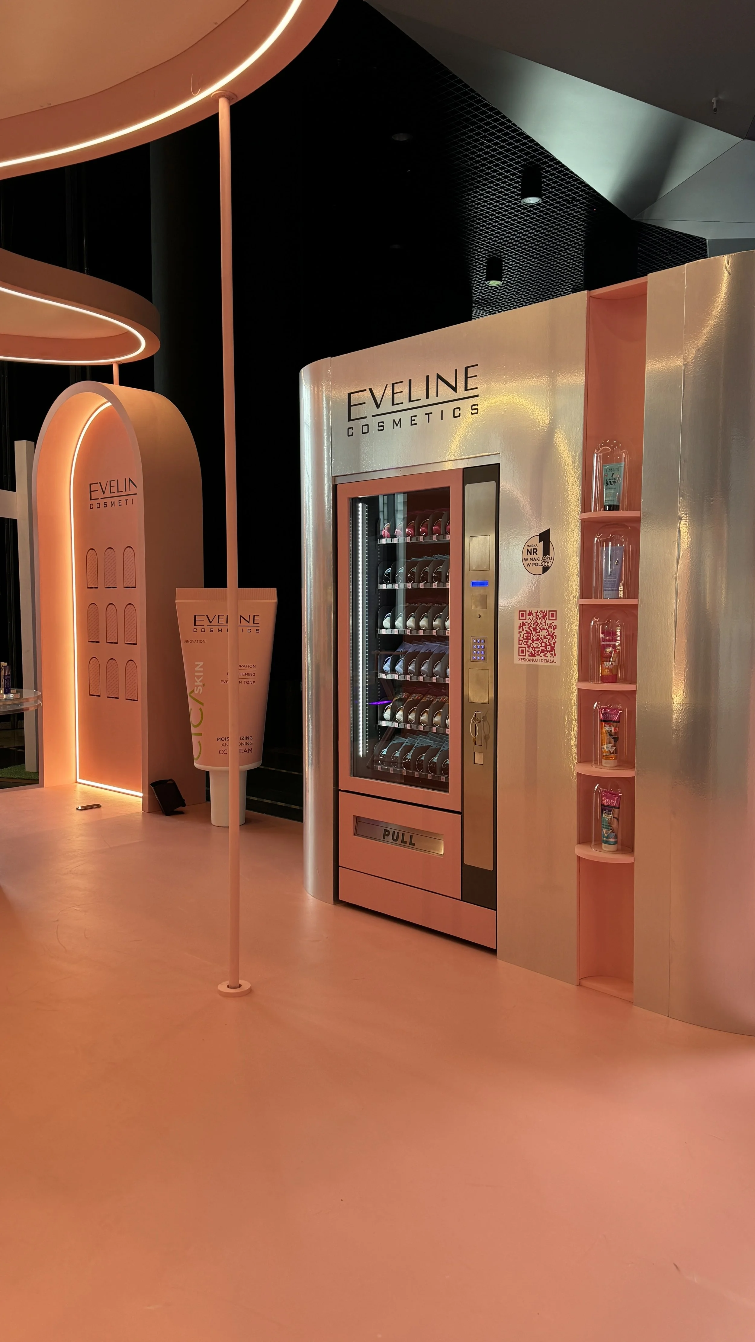 A vending machine next to a wall in a retail space, with shelves of colorful cosmetic products and a QR code.