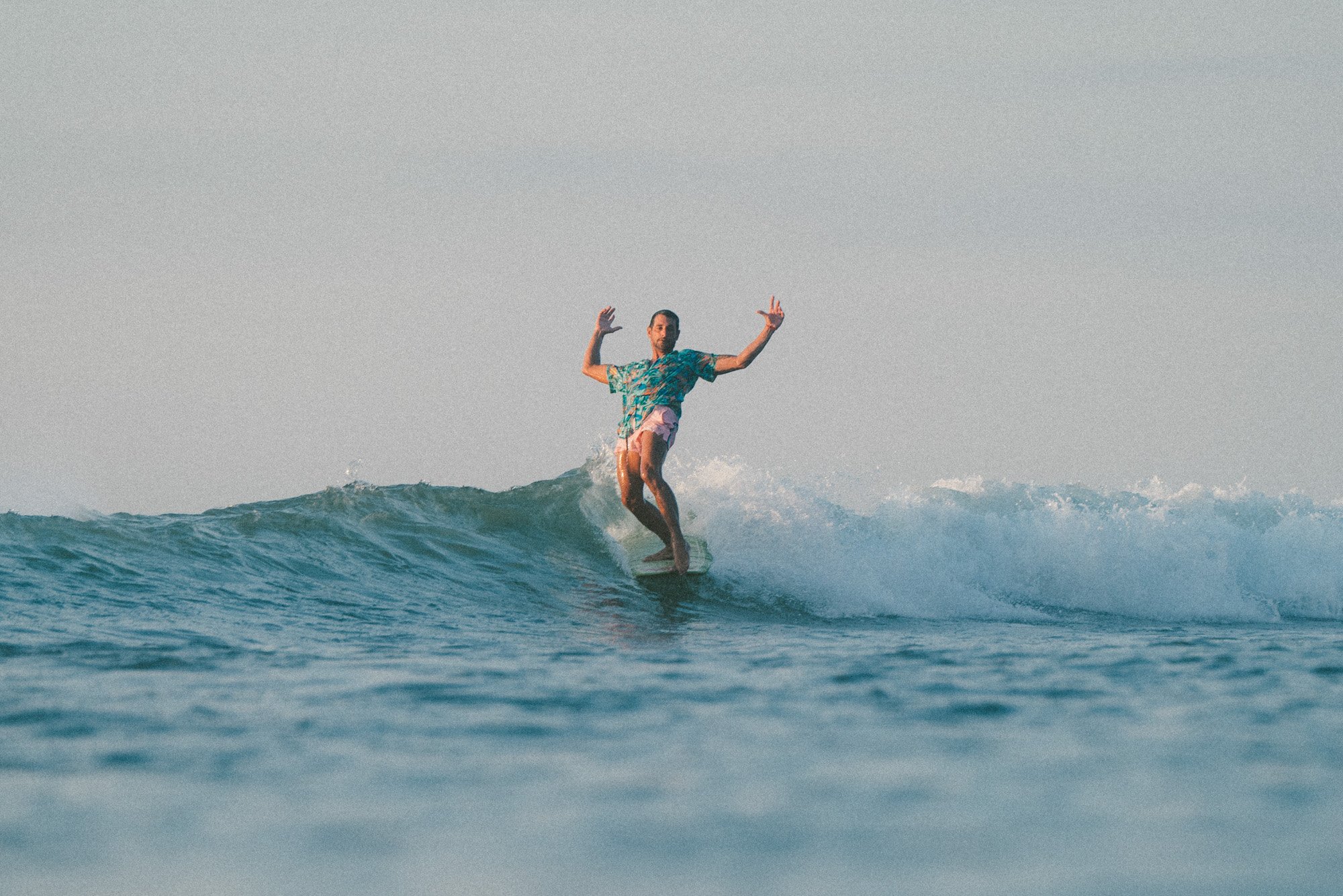 longboarder de camisa na onda pé no bico hang five