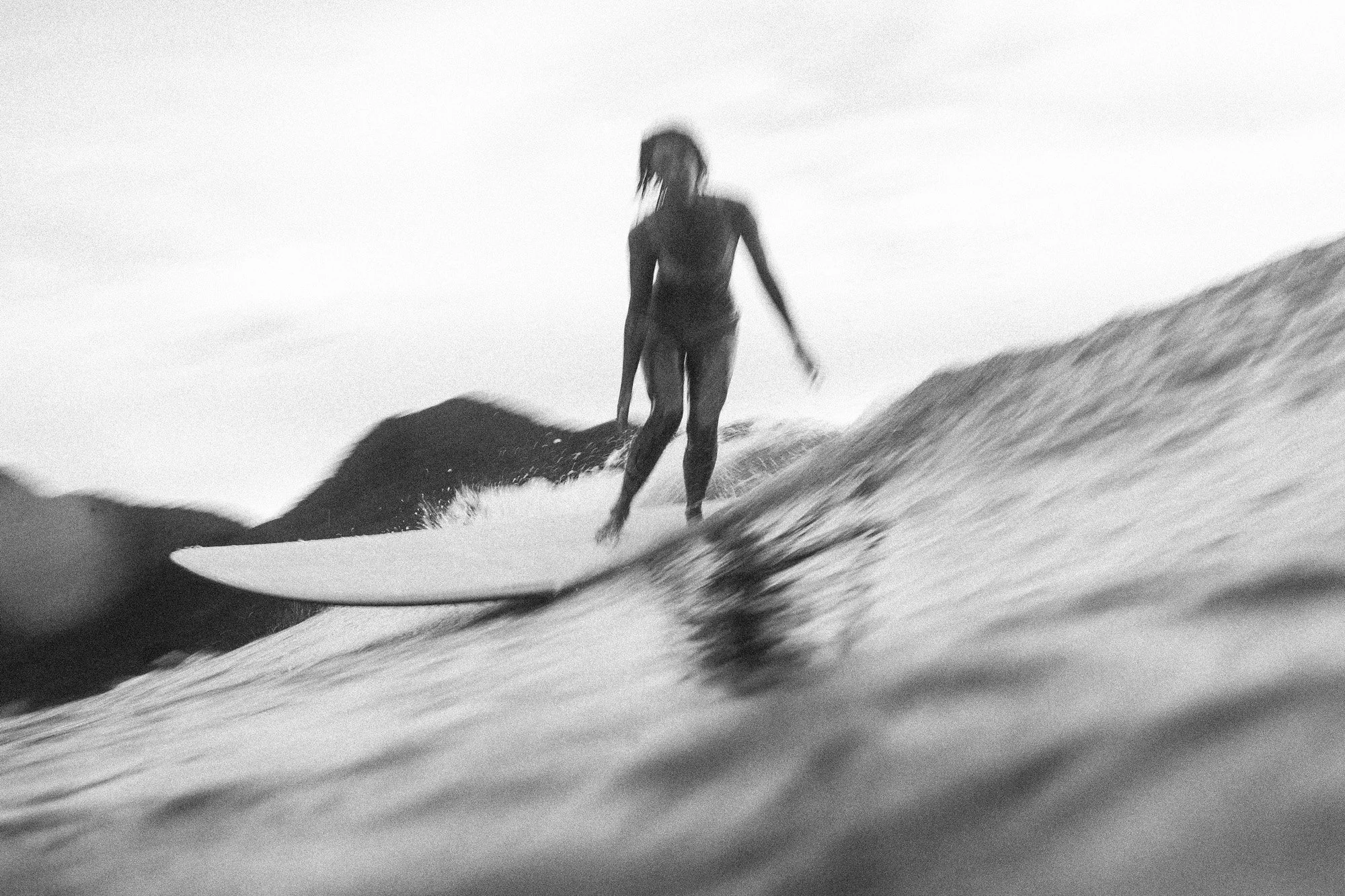 fotografia preto e branco da mari marcelli surfando de long em ubatuba