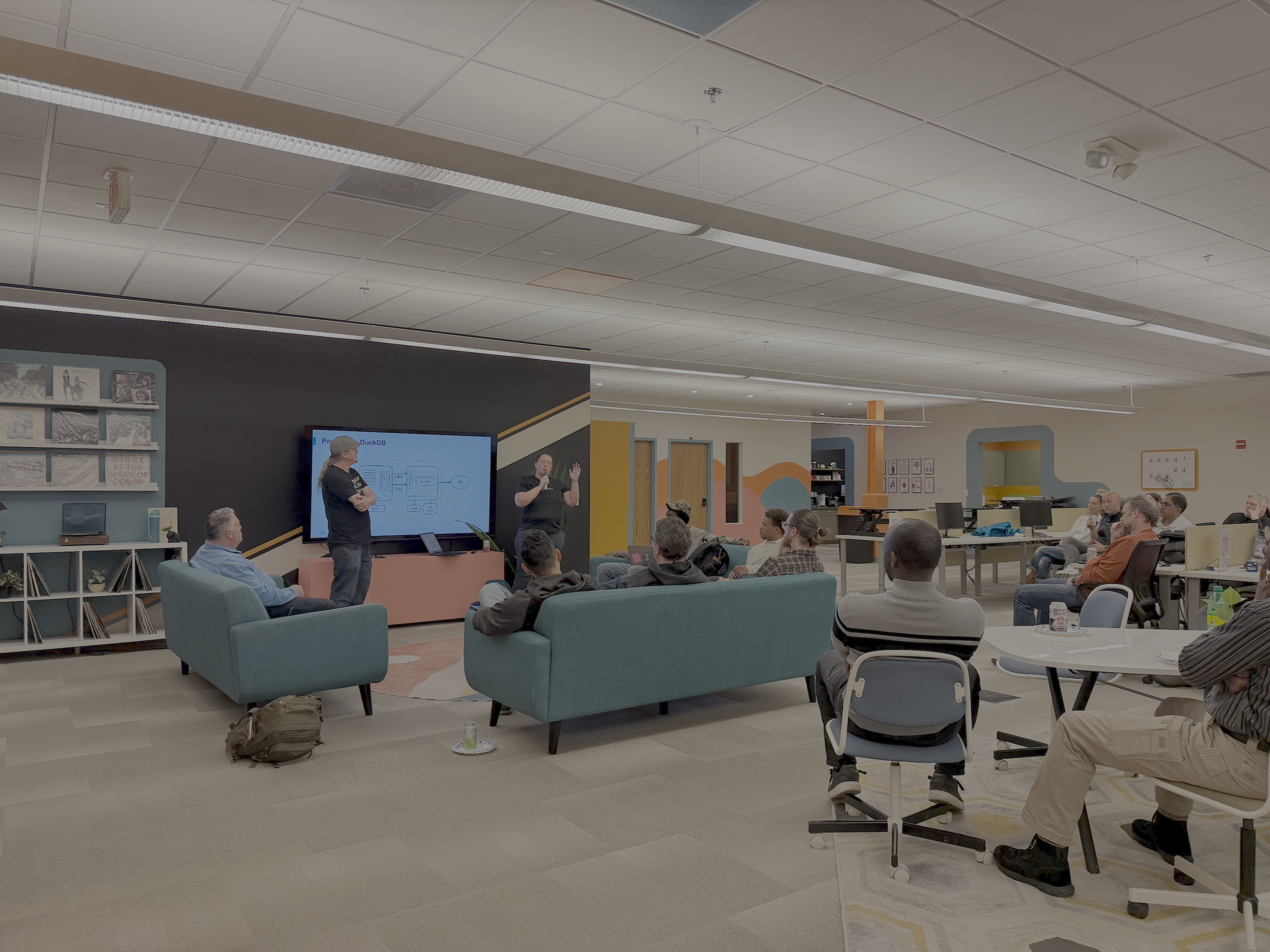 people hearing a presentation and sitting on couches and at tables