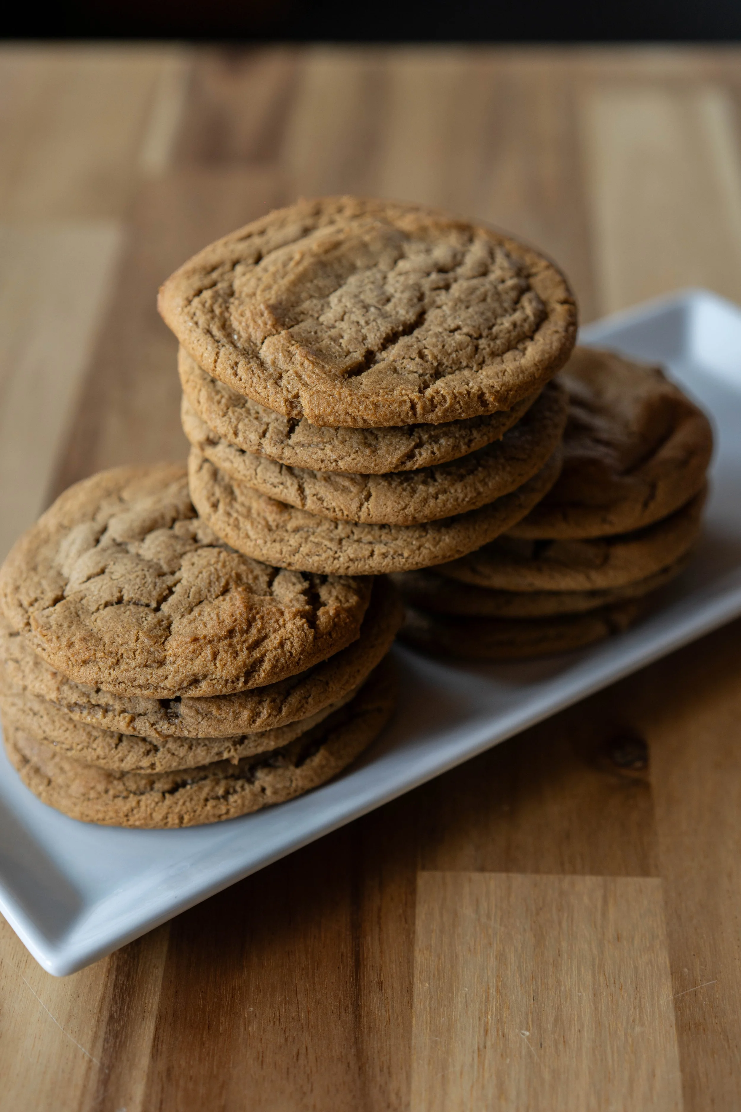 Stack of chocolate chip cookies on a white rectangular plate