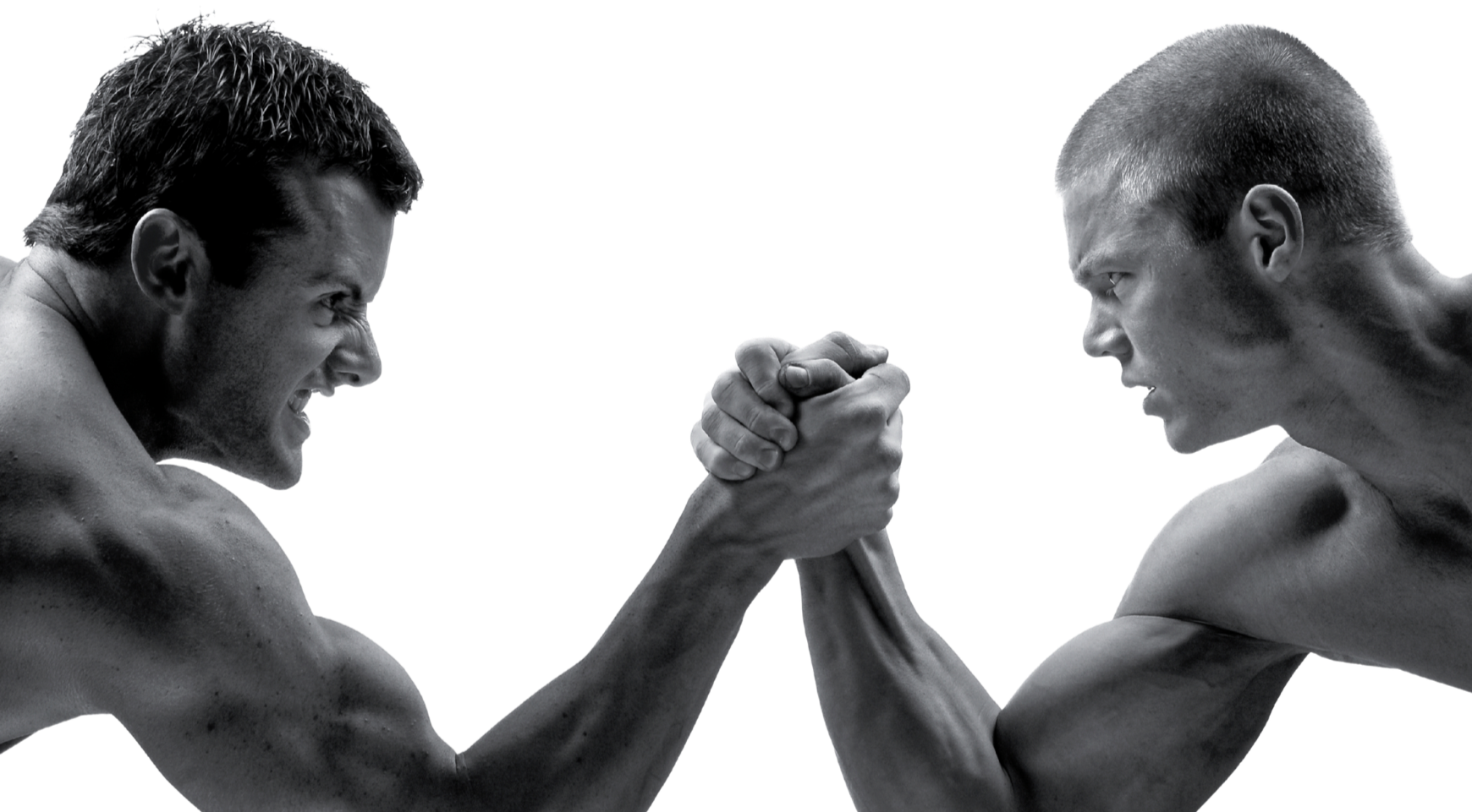 Black and white image of two shirtless men face to face, engaged in arm wrestling, with intense expressions.